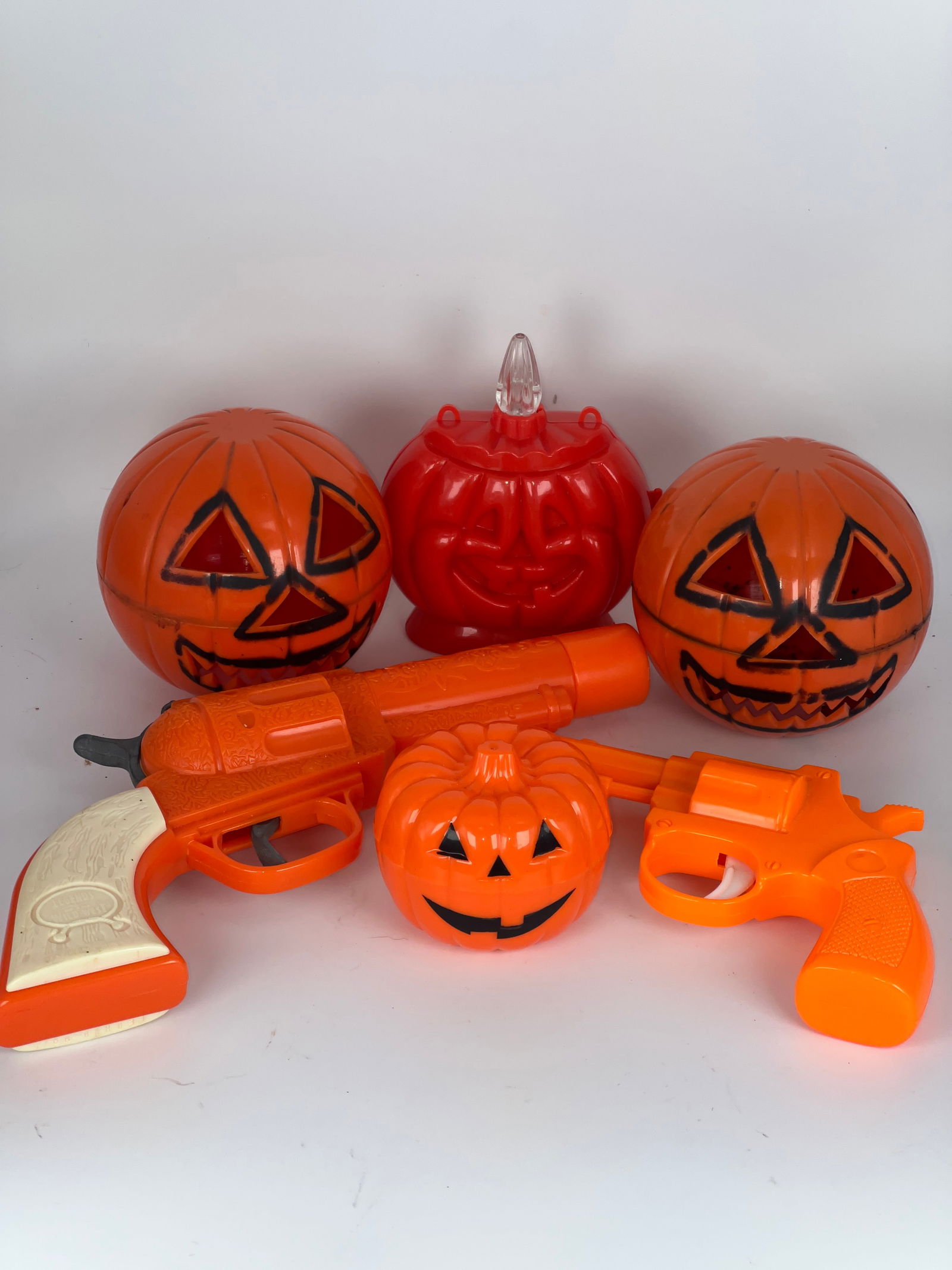 3 Plastic Candy Containers & 2 Toy Guns: 3 Plastic candy containers in Jack O'Lantern shapes - missing stoppers, 2 plastic guns for Halloween dress-up, & Johannsen pumpkin flashlight. Largest gun 9". Candy Container 3"