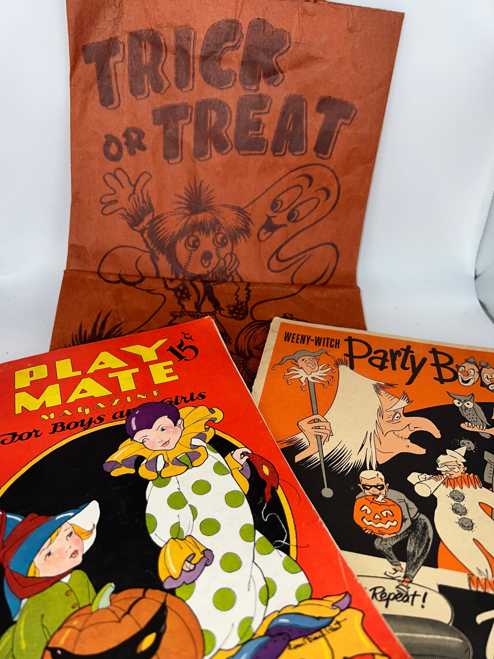 Two Vintage Halloween Books & Treat Bag: Weeny - Witch Party Book - Parrots Meets Advertising fold-out book, contains 2 cut out masks dates 1952, Playmate Magazine For Boys & Girls October 1933 Ed. & wax paper treat bag.