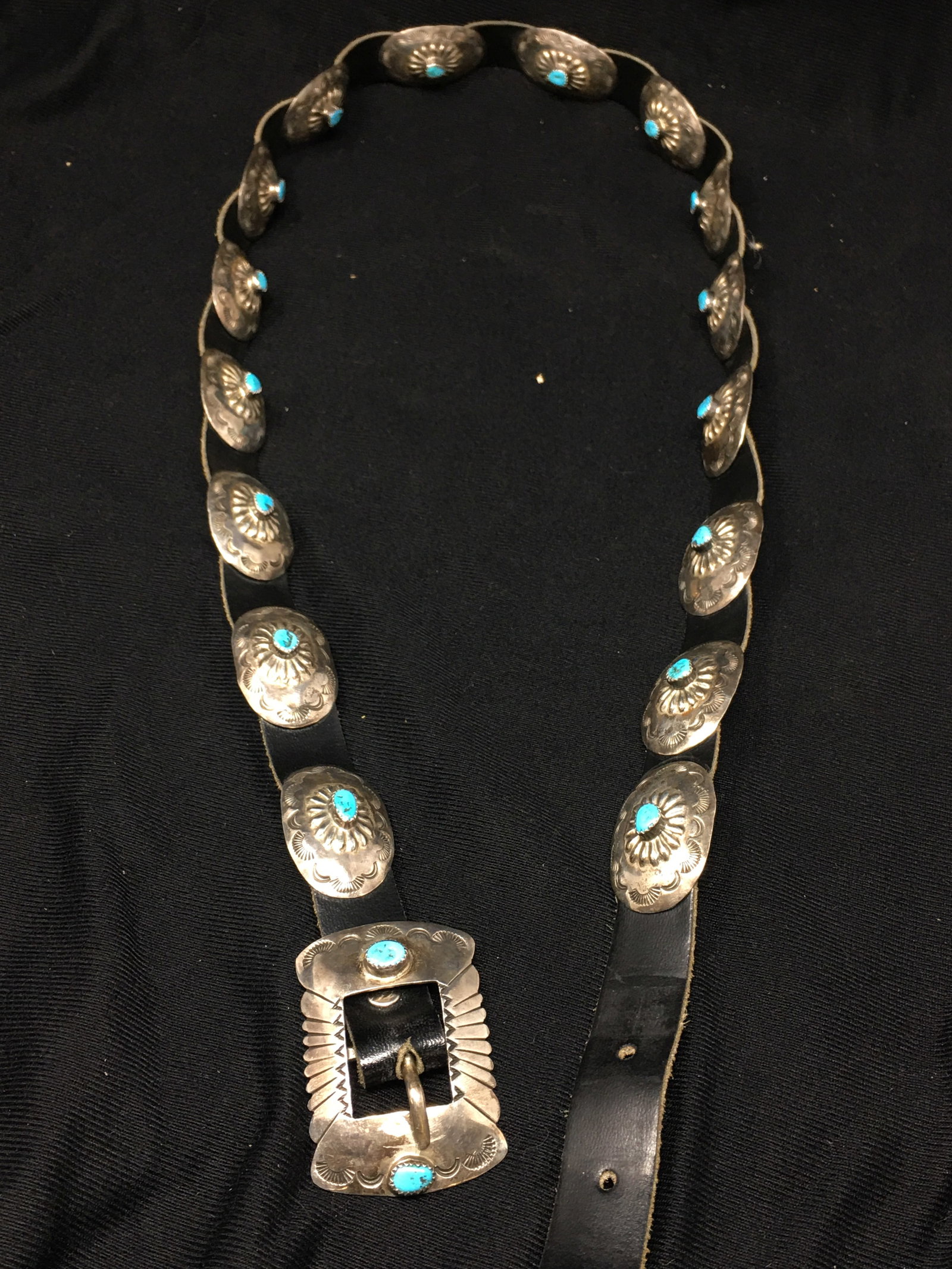 Navajo Concho Belt, Signed J: Navajo Concho Belt, Marked "J" and "Sterling", Jason Livingston, 16 conchos plus belt buckle with turquoise nuggets and decorated hand designs, belt size 36. From the Collection of Roselyn Potts.