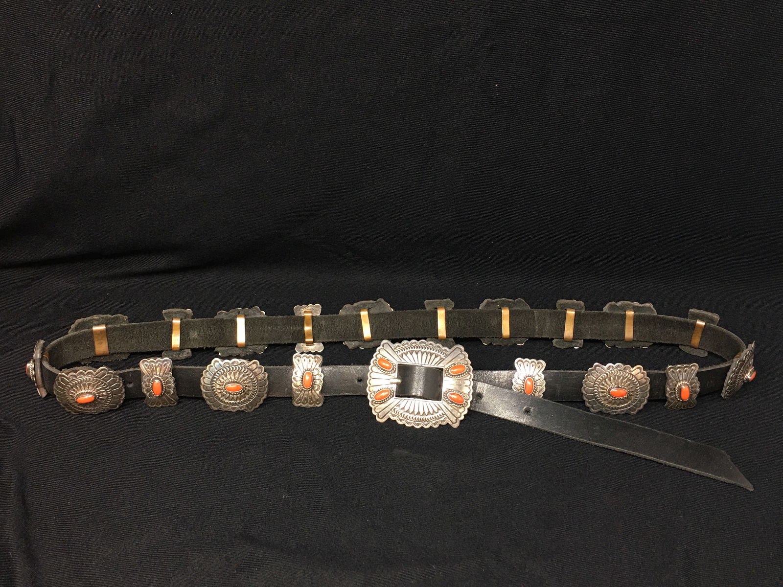 Sterling and Coral Concho Belt, Signed DM: Sterling and Coral Concho Belt, Signed "DM" and "Sterling", Daniel Martinez, size 34 belt, 19 leather backed conchos plus buckle with coral nuggets. From the Collection of Roselyn Potts.