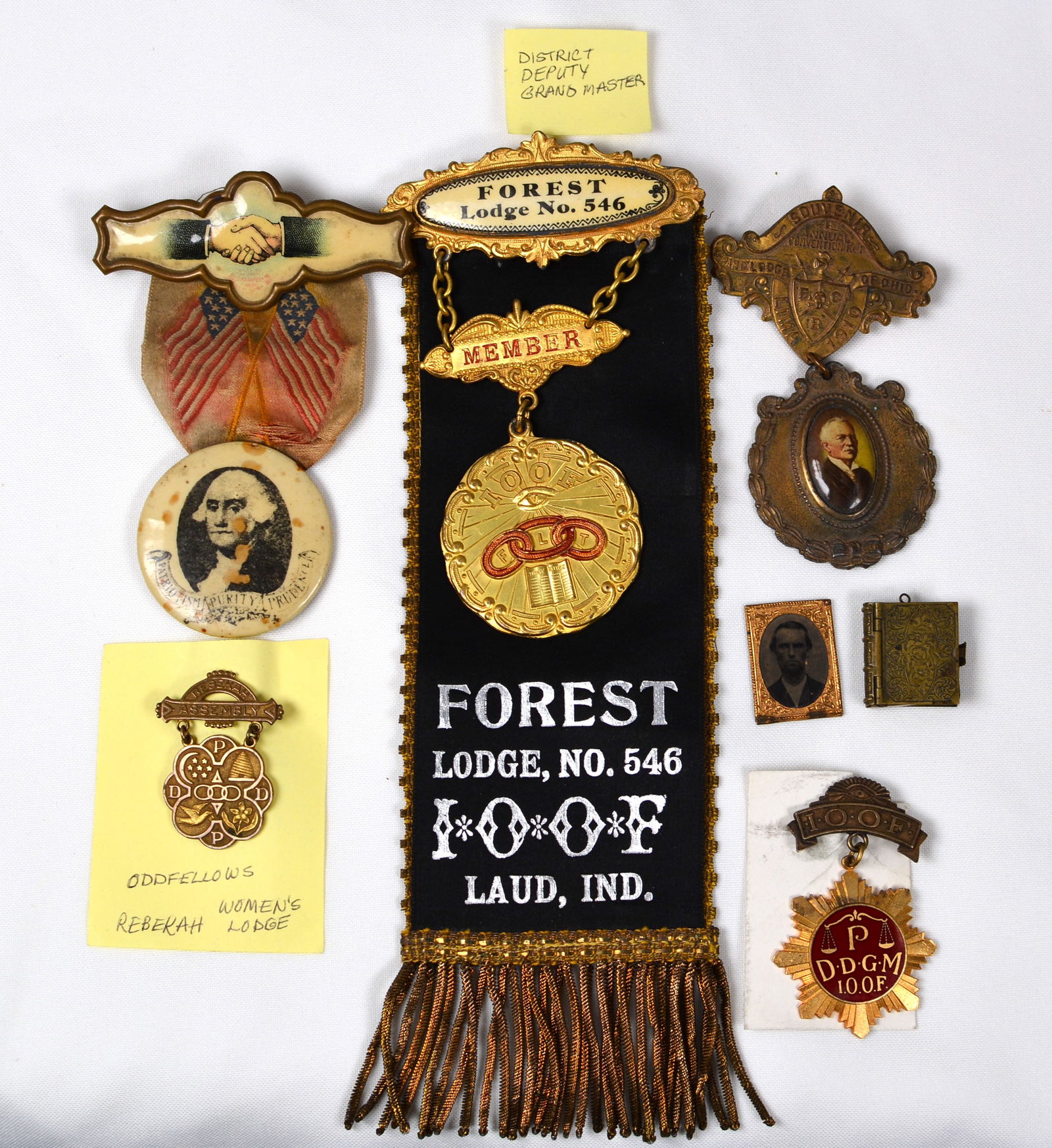 Group of Lodge Badges: Group of 5 of IOOF lodge badges includes Forest Lodge No. 546 Laud, Ind., IOOF Women's Lodge, Patriotic Purity & Prejudice, Ohio badge, & little metal locket book w/ miniature early photos of gentleme