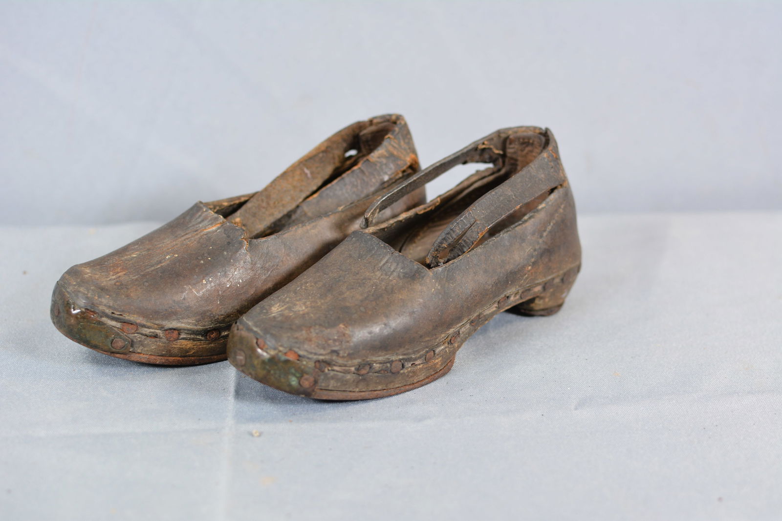 Early Wood & Leather Iron Shoes: Pair of child's leather shoes wooden soles w/horseshoe type iron trim on soles. 2 1/2"W x 6"L From the collection of Doug & Sandy Davies