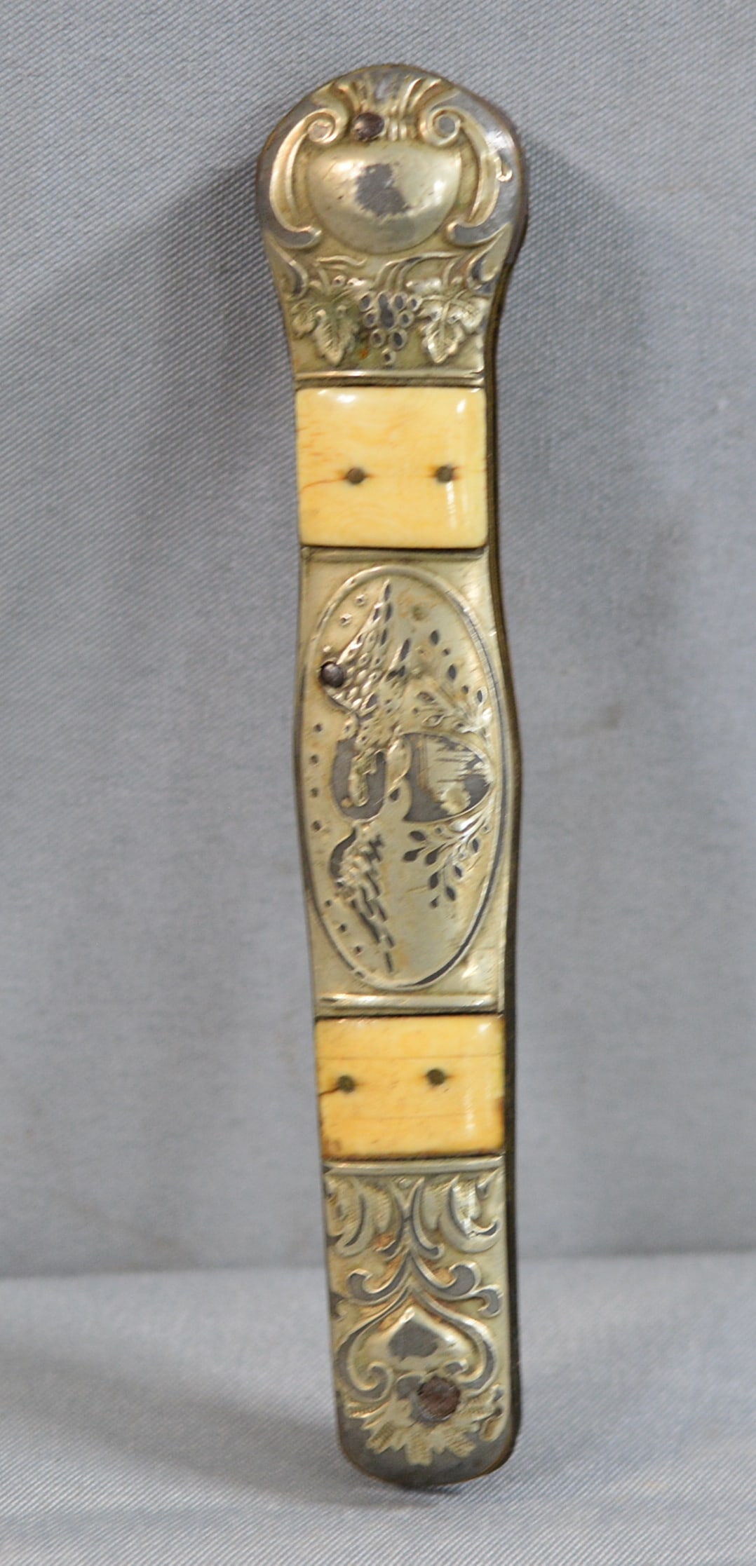 1850's Patriotic Knife Handle. Folding knife handle with Eagle and Shield center medallion flanked: 1850's Patriotic Knife Handle. Folding knife handle with Eagle and Shield center medallion flanked by 2 bands of natural material, scrolling and grape vine bolsters, the blades are missing, 6"x1"