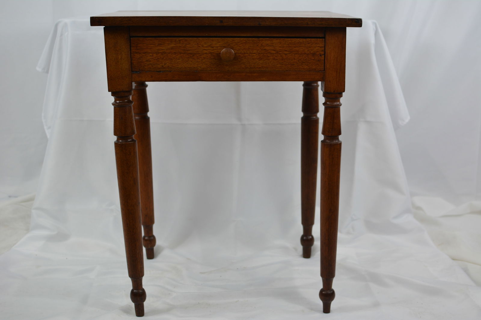 Walnut One Drawer Stand on turned legs, has dovetailed drawer, wood pull, one board top.: Walnut One Drawer Stand on turned legs, has dovetailed drawer, wood pull, one board top.