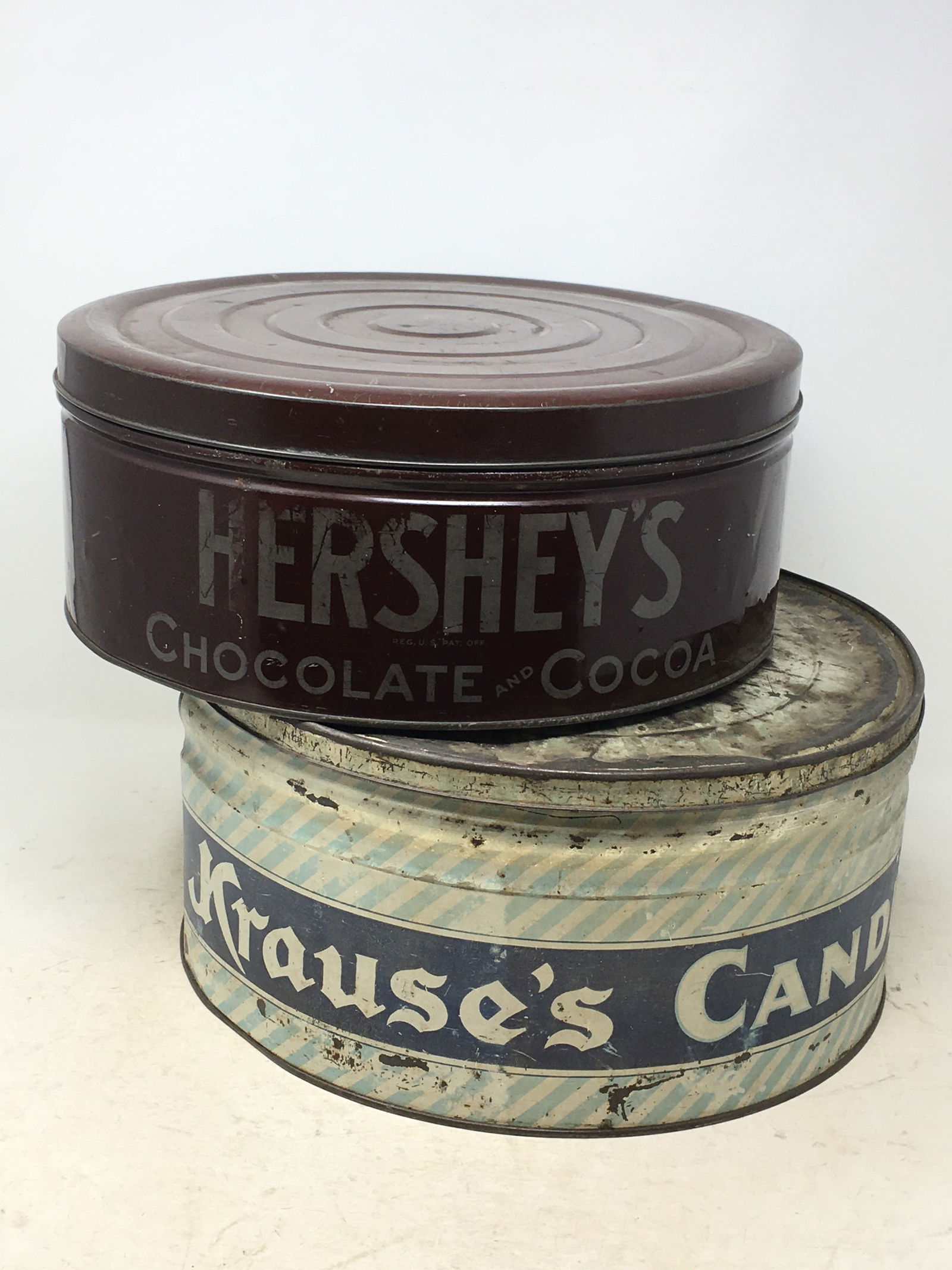 (2) Large Advertising Tins. 1) Hershey's Chocolate & Cocoa, 12.25"D x 4.75"H. 2) Krause's Candies,: (2) Large Advertising Tins. 1) Hershey's Chocolate & Cocoa, 12.25"D x 4.75"H. 2) Krause's Candies, Tru-Blue Biscuit Company, Spokane & Portland, rough graphics on lid & a dent at bottom. 12.25"D x 5.7