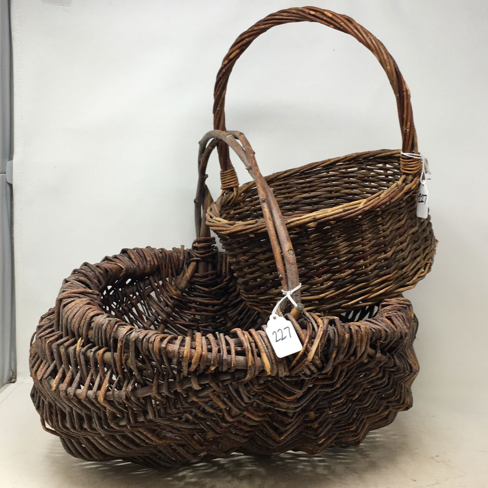 (2) Woven Twig Baskets. 1) Buttocks Basket with Twig Handle, 17"L x 16"W x 14"H; 2) Flat bottom (1 of 6)