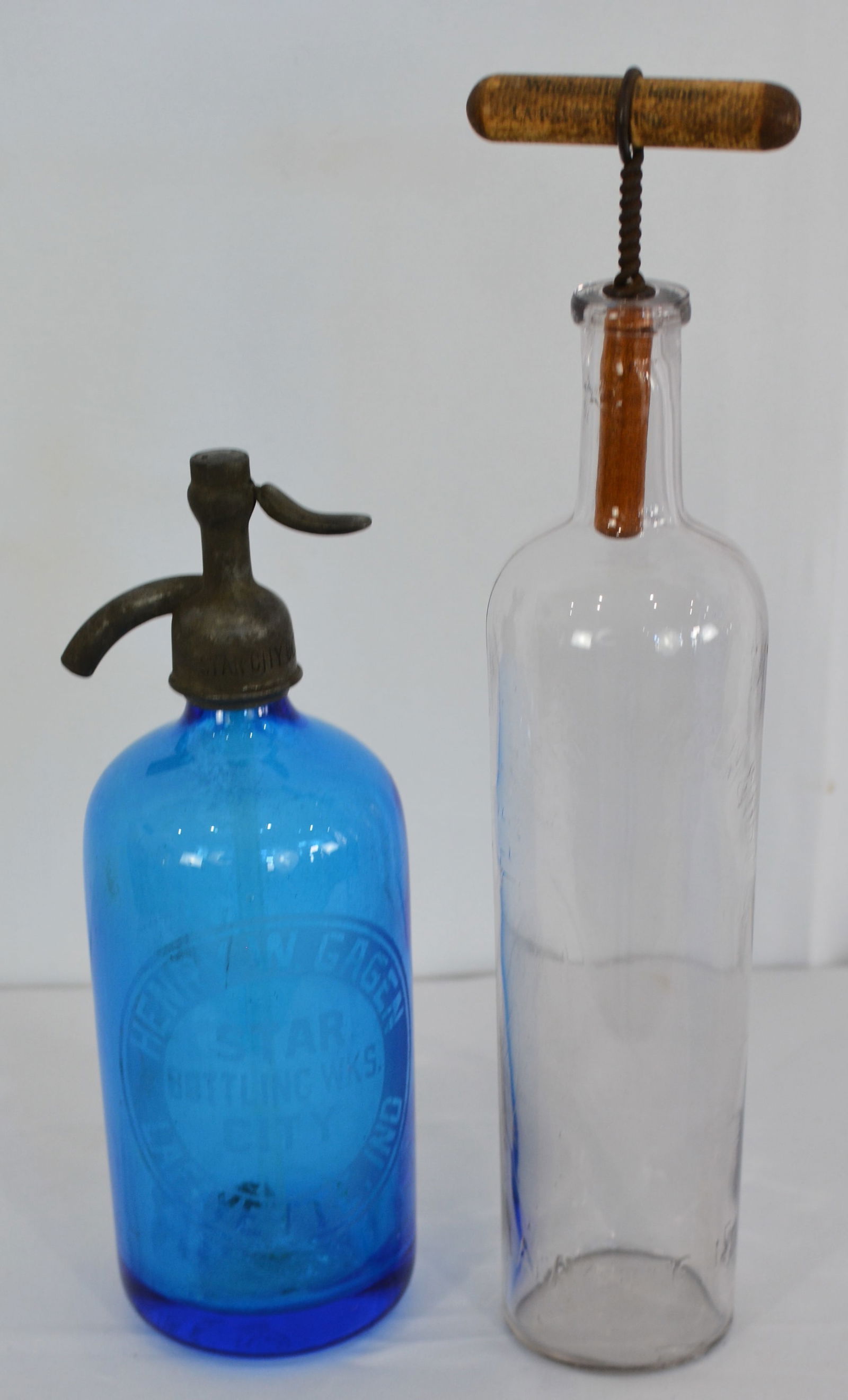 Two early Lafayette Ind. bottle. One blue spritzer bottle etched lettering. One clear with embossed: Two early Lafayette Ind. bottle. One blue spritzer bottle etched lettering. One clear with embossed lettering & advertising wood stopper. Both Gagen advertising. Tallest is 14"T x 3"Dia