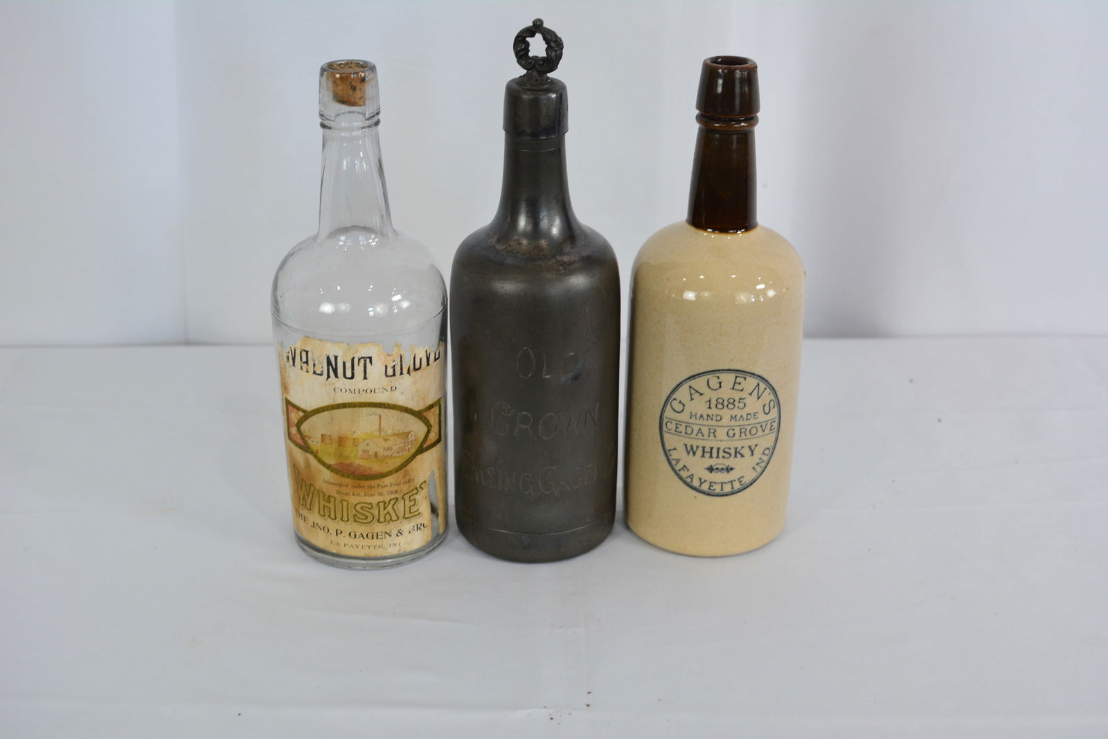 Three Gagon advertising bottles: one glass w/paper label, one metal engraved "Old Crown" bottle, one (1 of 7)