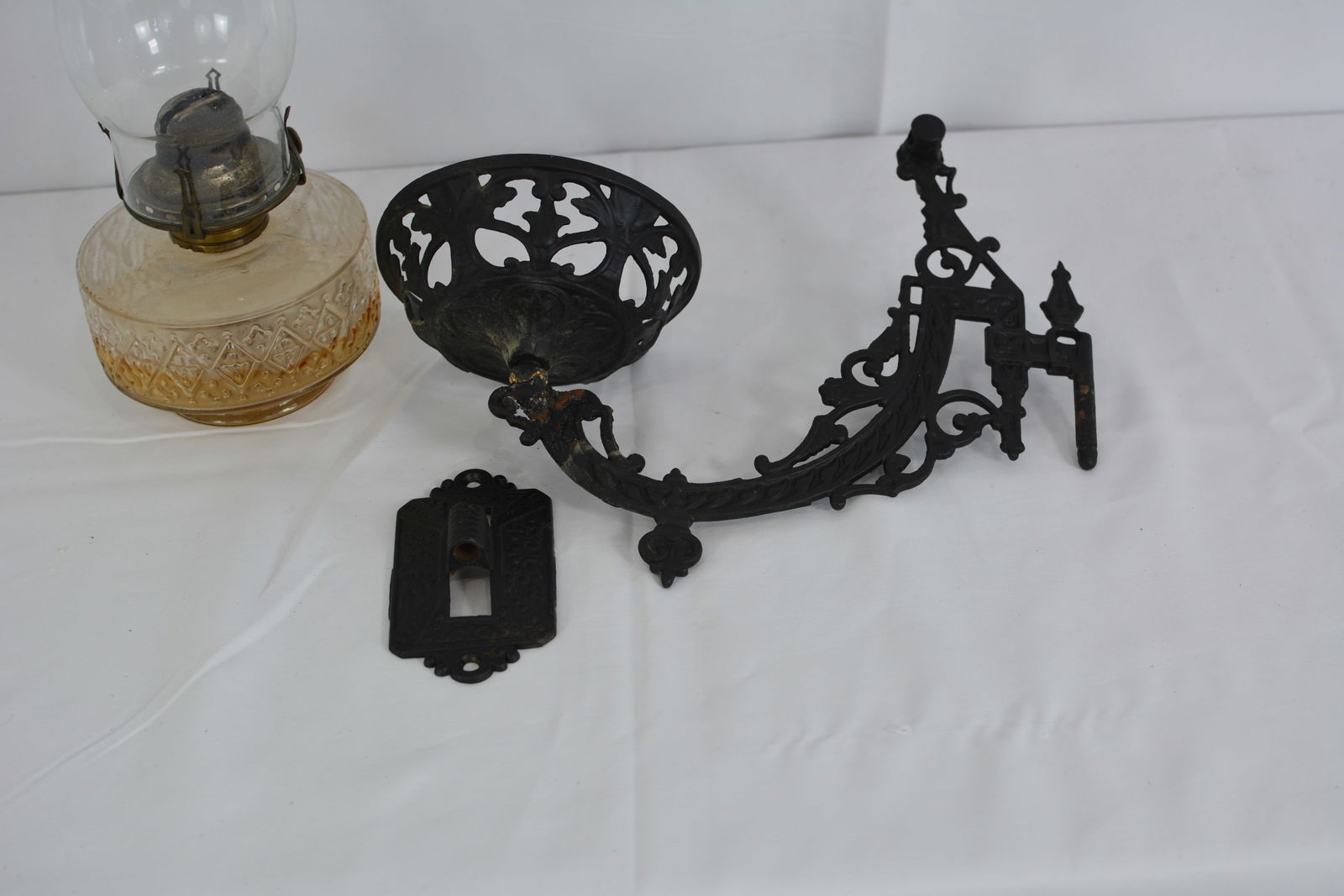 Cast iron bracket lamp w/ clear glass bowl & chimney. 15"W x 12"T x 6"D: Cast iron bracket lamp w/ clear glass bowl & chimney. 15"W x 12"T x 6"D