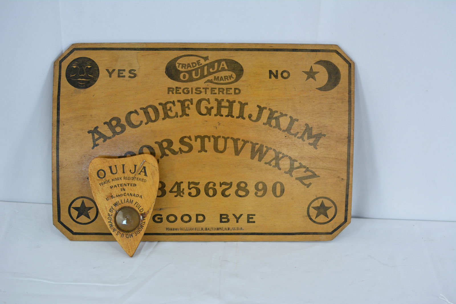 1910s Ouija board made by William Fuld Baltimore MD USA, includes black stenciled panel w/: 1910s Ouija board made by William Fuld Baltimore MD USA, includes black stenciled panel w/ directions on back, & heart shaped planchette w/viewing window. 12" x 18"