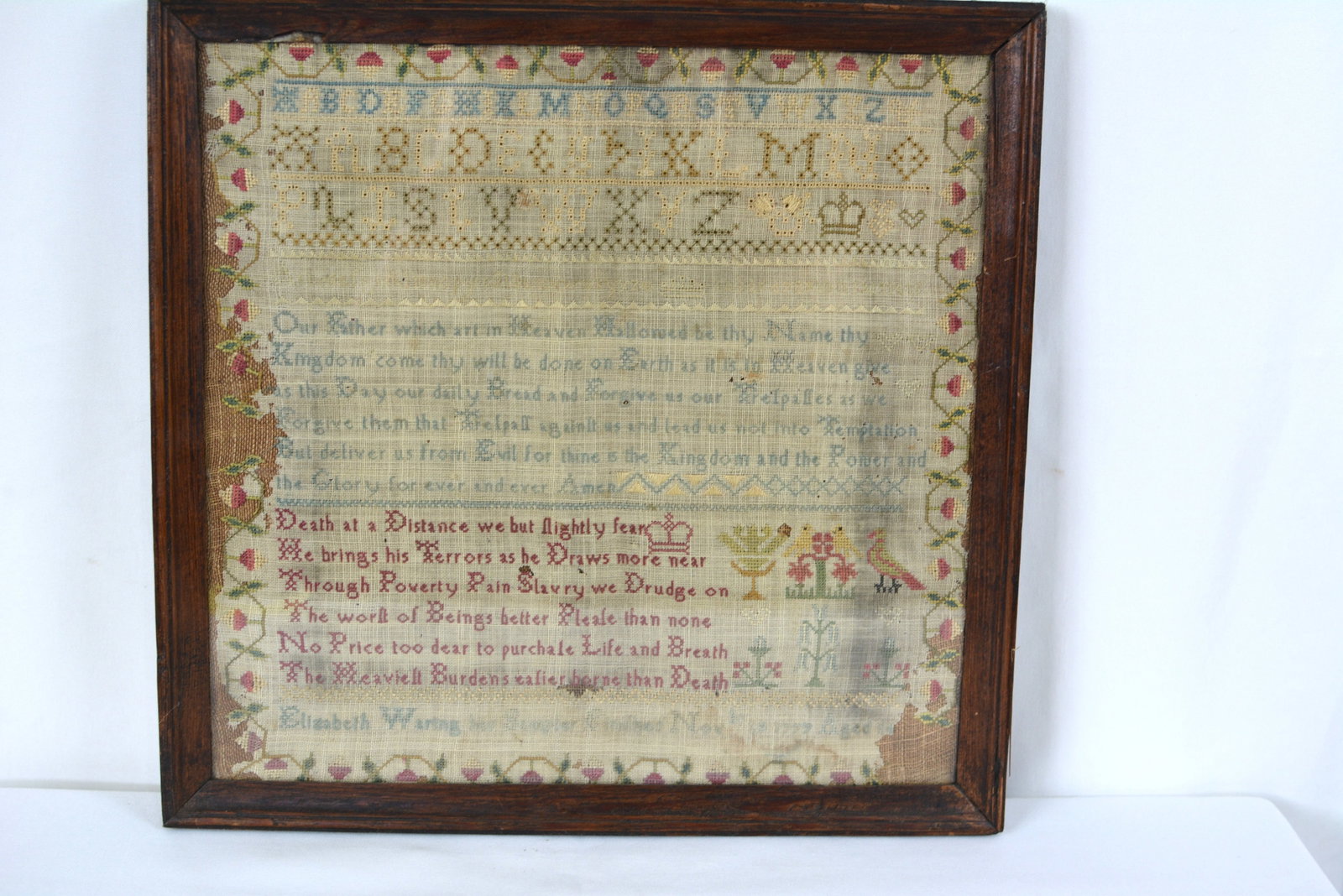 Framed 1846 Needlework Sampler by Elizabeth Warne: Mid-19th century silk and wool needlework sampler by Elizabeth Waring and dated Nov19, 1779. The sampler features a religious verse, decorative floral borders, birds, flowering plants, and