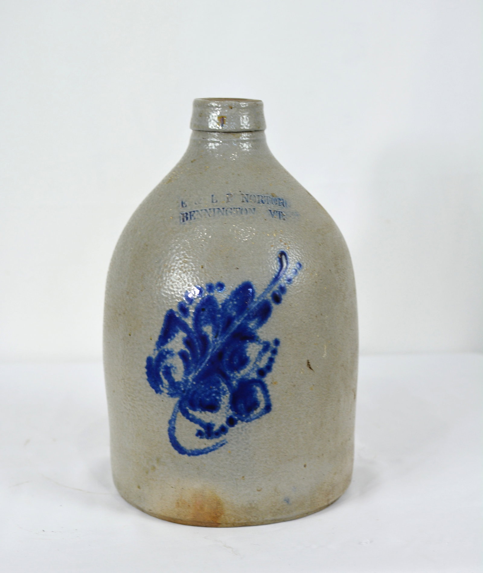 L. P. Norton Bennington, Vermont Stoneware Jug with Cobalt Floral Decoration: cobalt blue floral decoration on the front. Size: 7 in. Dia. x 12 in. H