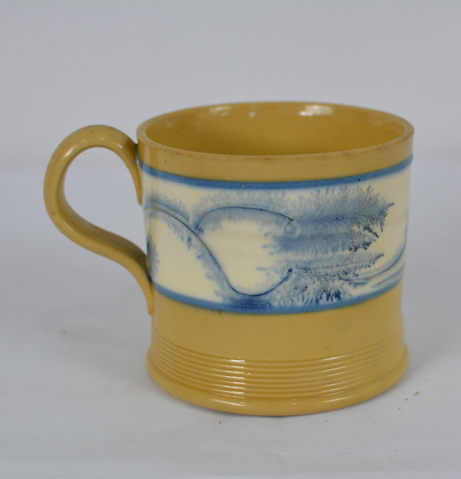 19th Century Mocha ware Tankard with Blue Decoration: Attractive 19th-century English mocha ware tankard featuring a cream-colored central band decorated with vivid blue mocha slip decoration. Size: 4 1/2 in. W x 3 1/2 in. D x 3 in. H.