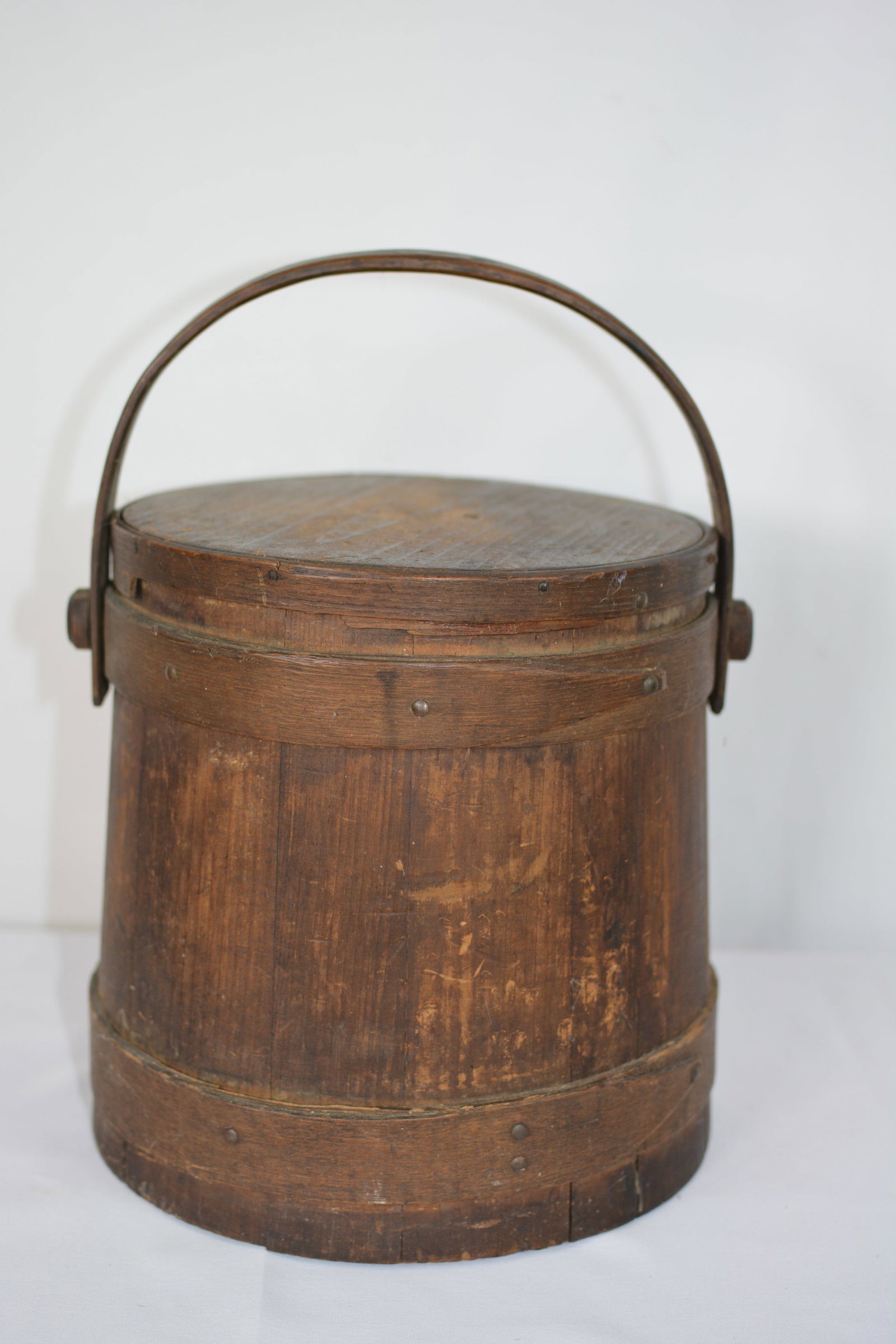 Wooden Firkin Bucket with Lid and Swing Handle Natural Finish: Early natural finish wooden firkin bucket bentwood bands. Lid has condition issue. Size: 10 1/2 in. H x 10 in. Dia. (excluding handle)