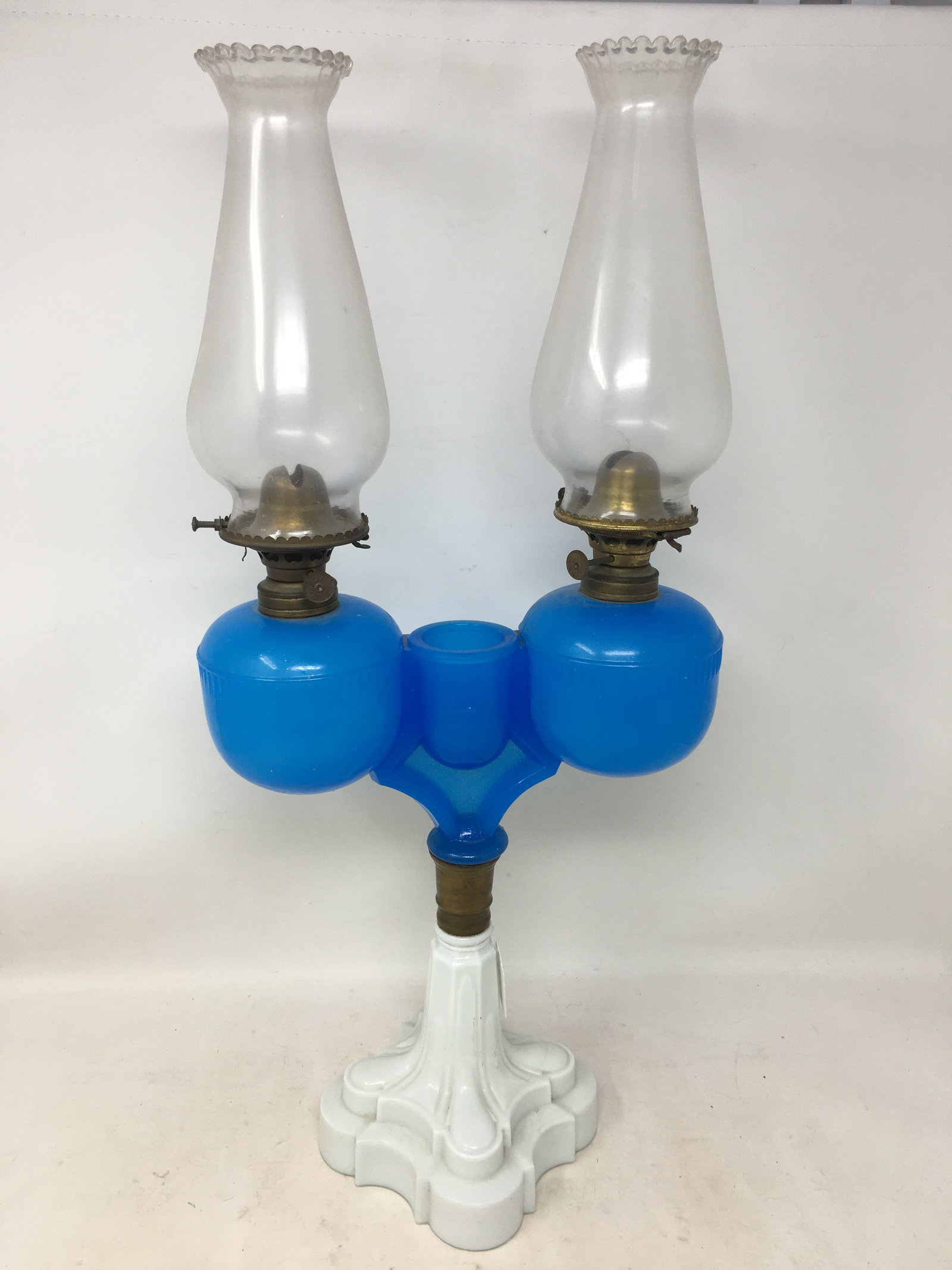 Ripley Double Wedding Lamp: Ripley Double Wedding Lamp, blue & white, with center match holder. Milk glass base with clam broth kerosene oil fonts. Hairline to back of right bowl. 9.5"W x 20.5"H w/ chimneys.