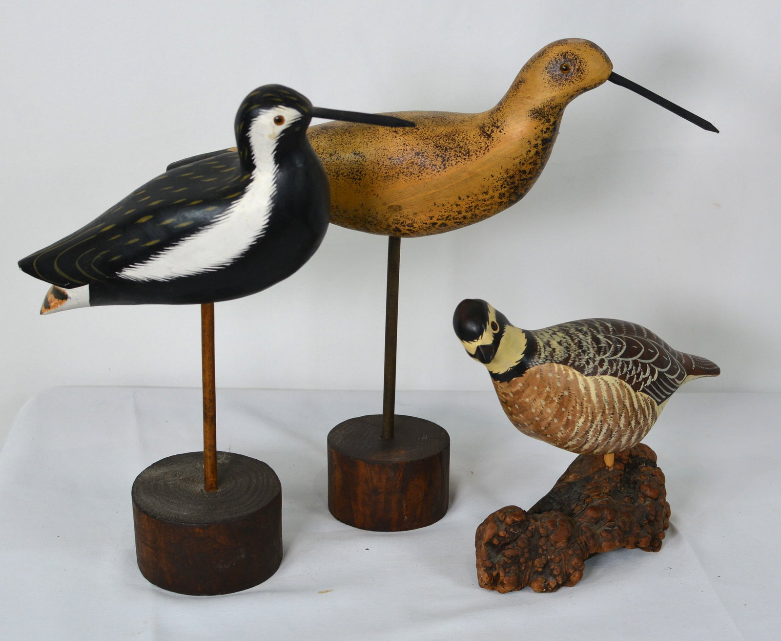 Collection of Three Folk Art Shorebird and Game Bird Carvings, Including Signed Example: Collection of three carved and hand-painted bird sculptures, including two shorebirds mounted on turned wood bases and a carved game bird mounted on a natural burl wood base. The game bird carving is