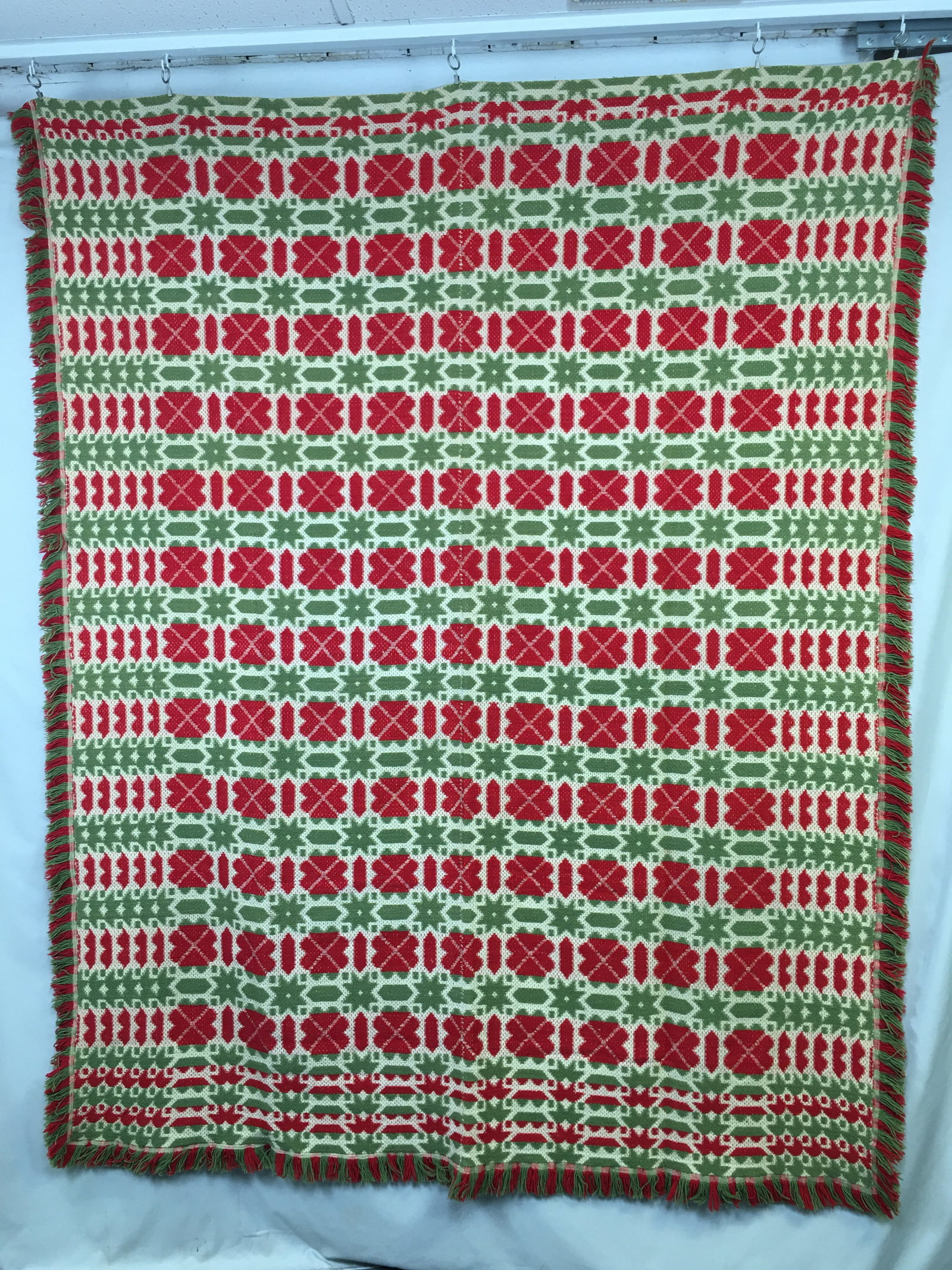 Three Color Woven Fringed Coverlet: Three Color Woven Fringed Coverlet. Two panel, in red, green & tan, with hearts, stars & bars design. Fringed on three sides. 94"x76" without fringe.