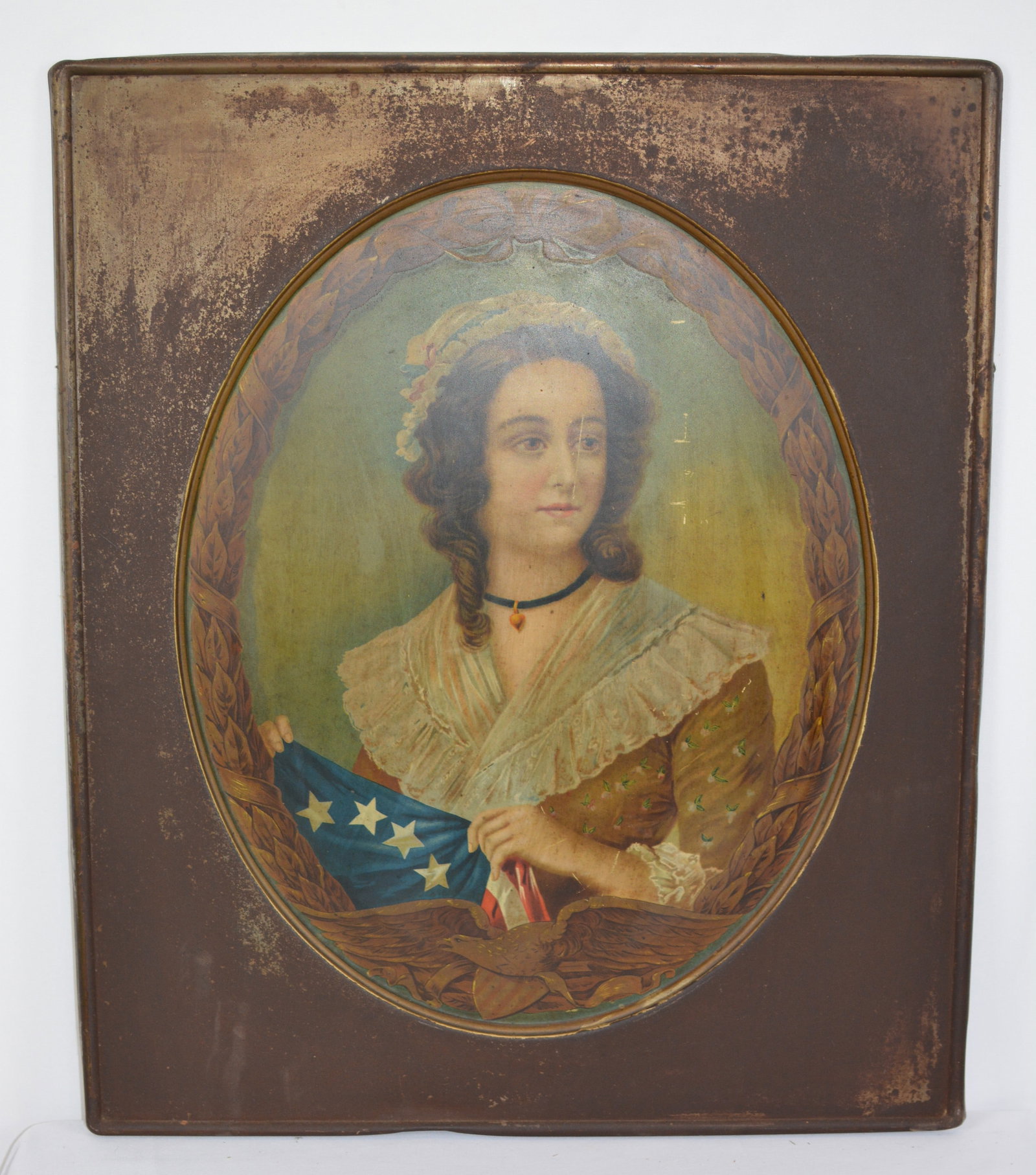 19th Century Patriotic Lady Tin Lithograph: Lithographed tin advertising or patriotic display sign featuring a young woman holding a portion of the American flag within an oval laurel wreath and eagle border. The sign retains its original