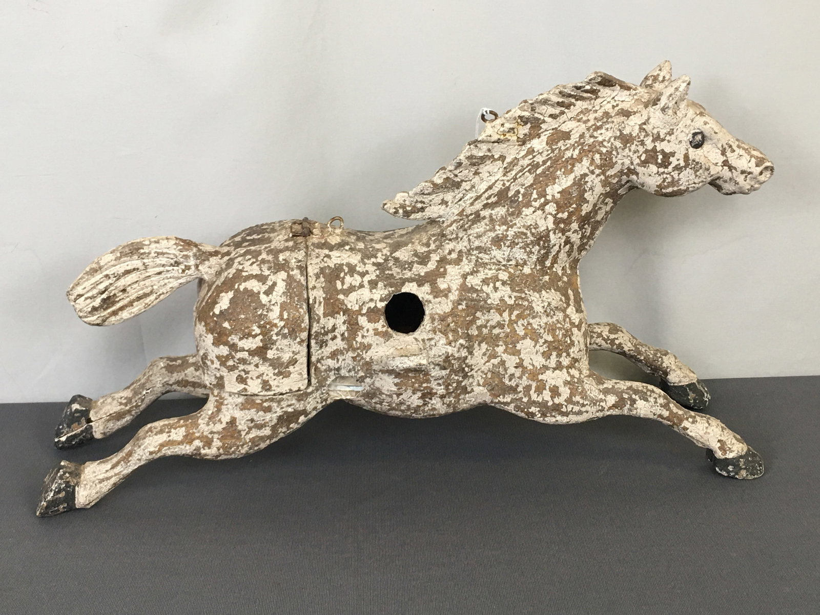 Horse Form Fiber Bird House: Horse Form Fiber Bird House. Running horse in old white paint with hinged rear. Approx quarter-size outer shell loss to one flank and two small chips on opposite outer back leg. . 19"L x 5"W x