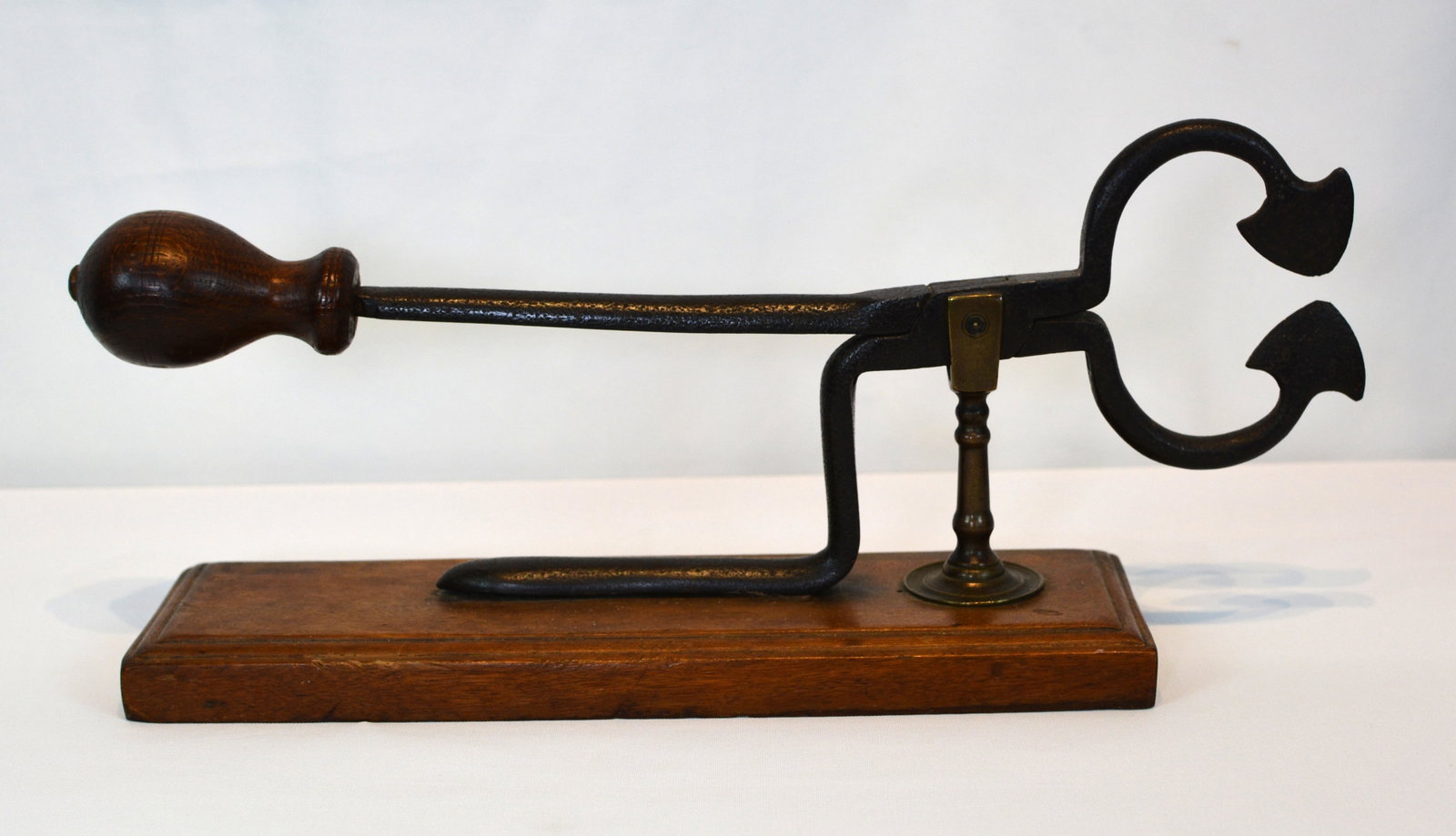 19th Century Cast Iron Sugar Nippers with Turned Wooden Handle on Display Stand: A 19th century pair of cast iron sugar nippers with a turned wooden handle and distinctive curved cutting jaws, used for clipping portions from cone-shaped sugar loaves. 14" L x 3½" W x 6" H (o