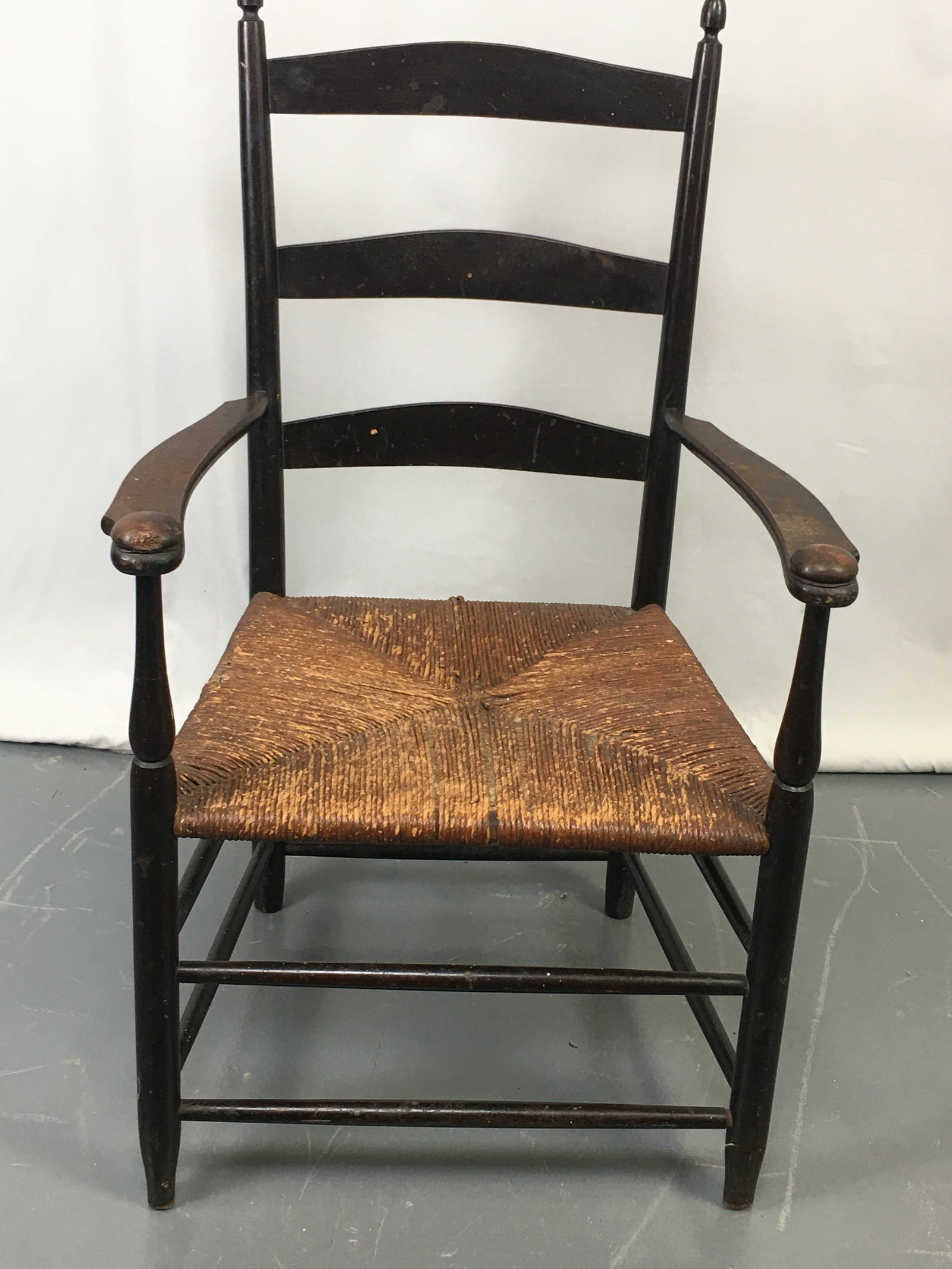 Mount Lebanon Shaker #5 Arm Chair: Mount Lebanon Shaker #5 ladder back arm chair in black paint. Shaped arms with mushroom caps. Marked Shaker's, Mount Lebanon New York, No. 5". With stamped 5 on top rung. Rush bottom, some loose