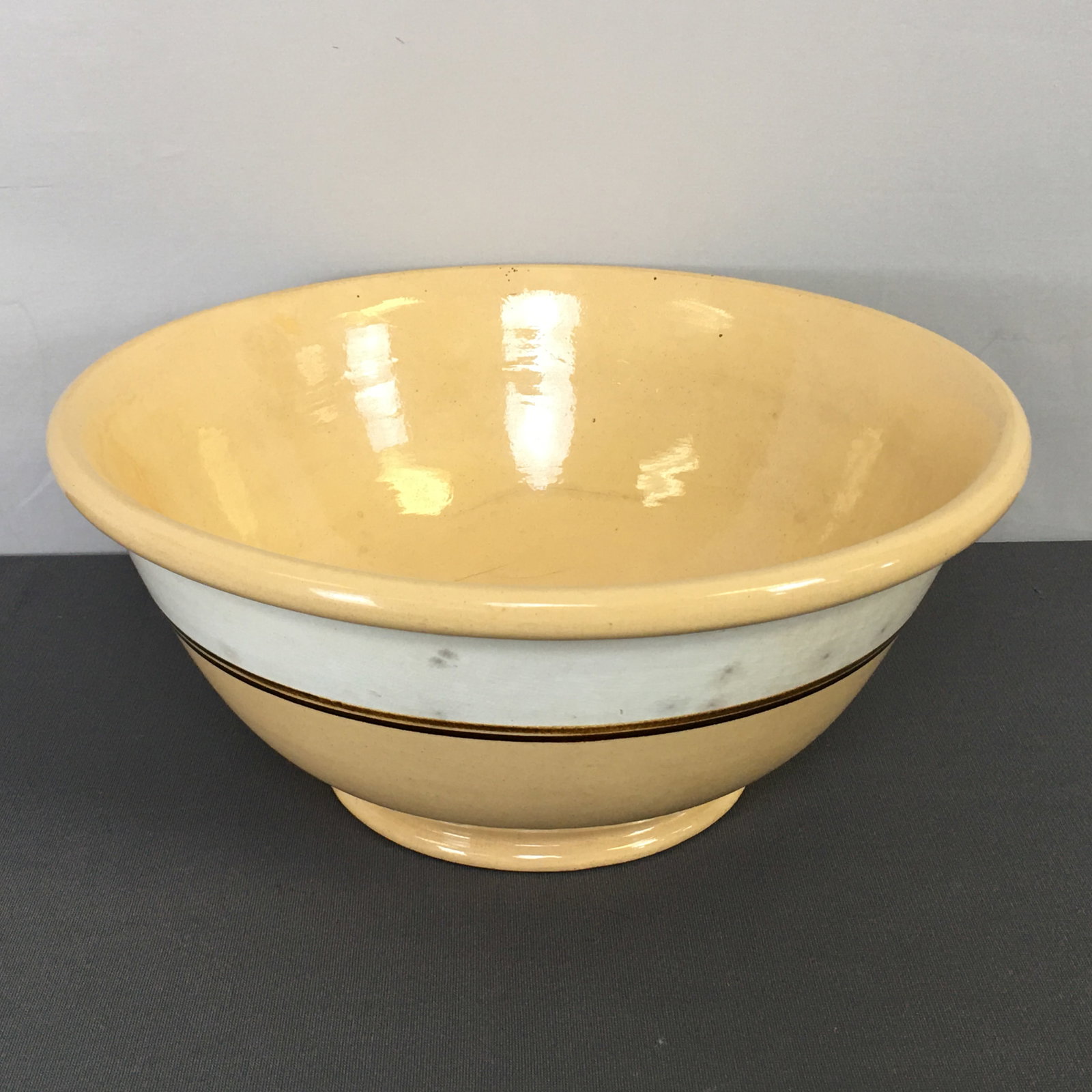 Large Yellowware Mixing Bowl: Large Banded Yellowware Mixing Bowl. Thick white mocha-style band underscored by two thin brown bands. 14.25"D x 6.25"H