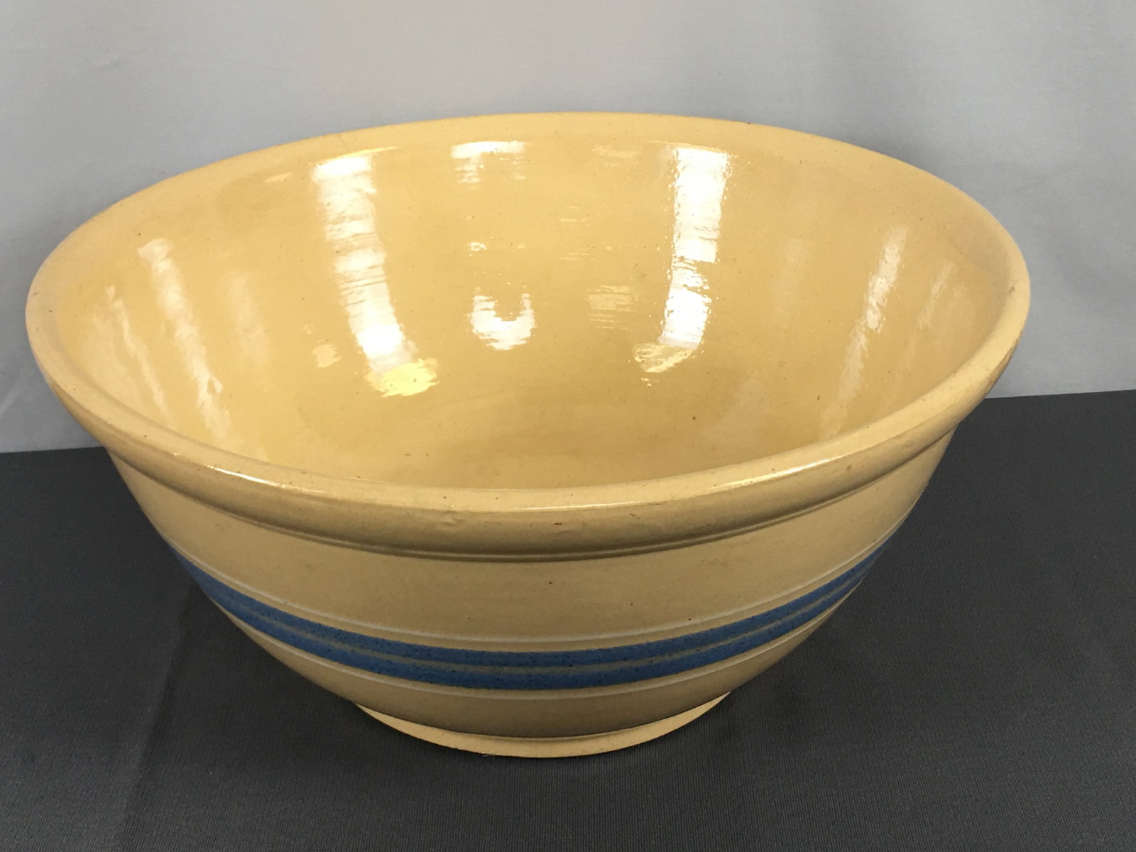 Large Banded Yellowware Mixing Bowl: Large Banded Yellowware Mixing Bowl. Blue band flanked by white bands. Bottom marked 168. 14.5"D x 6.75"H.