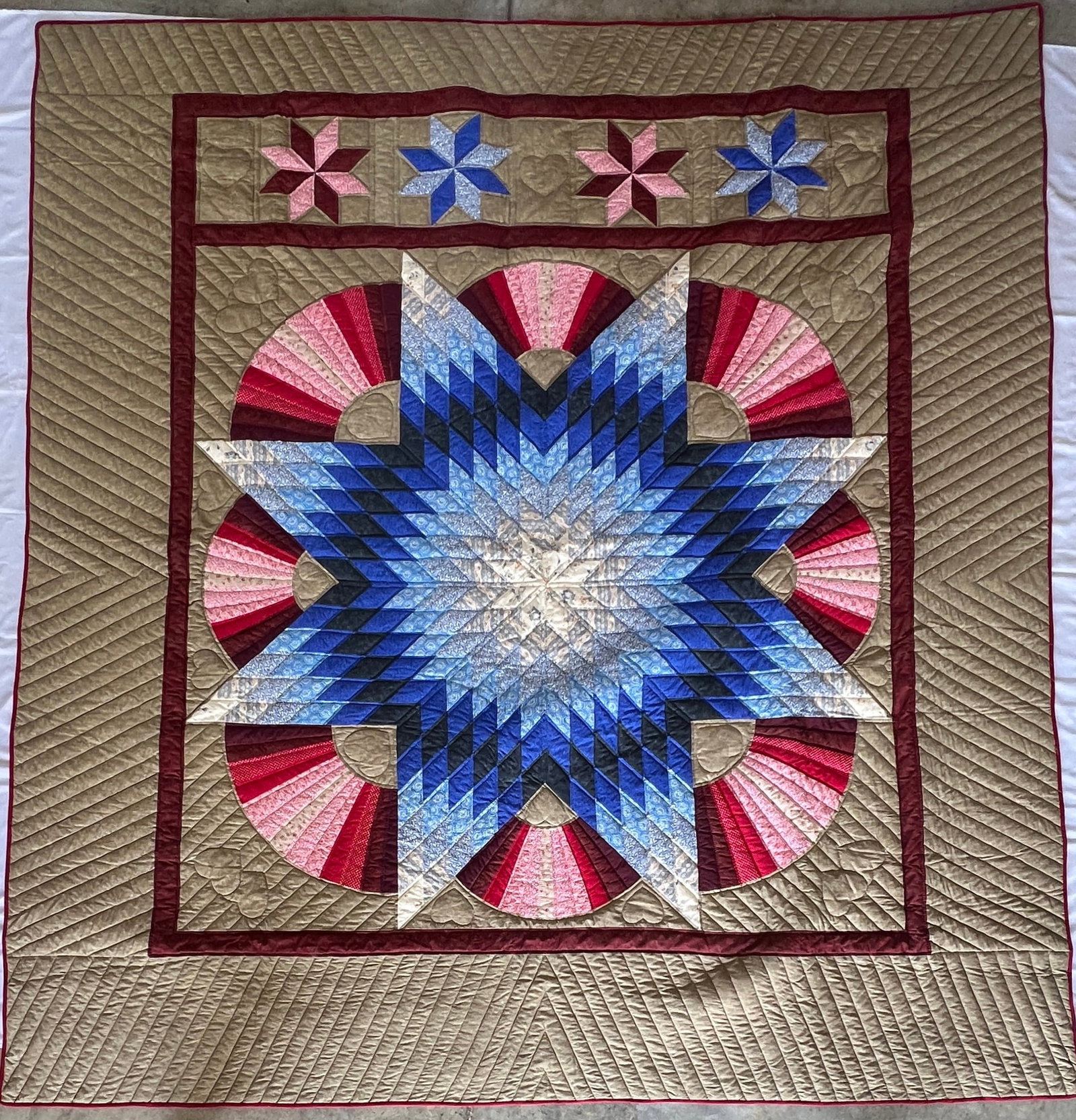 Handcrafted Lone Star Quilt with Fan Motif – 98" x 105": Large handcrafted quilt featuring a striking Lone Star pattern accented by dramatic fan motifs and intricate machine quilting. The central eight-point star is composed of graduated shades of blue,