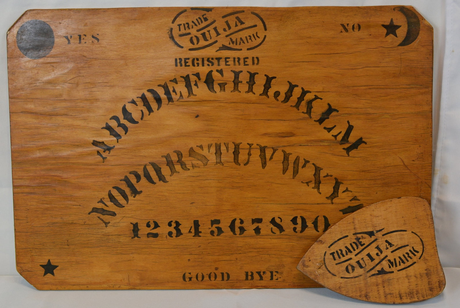 Rare Ouija Black Stenciled Board with Planchette: Scarce early wooden advertising display for the famed Ouija talking board, featuring bold black stenciled lettering reading “Registered ABCDEFGHIJKLM NOPQRSTUVWXYZ” and the trademark Ouija