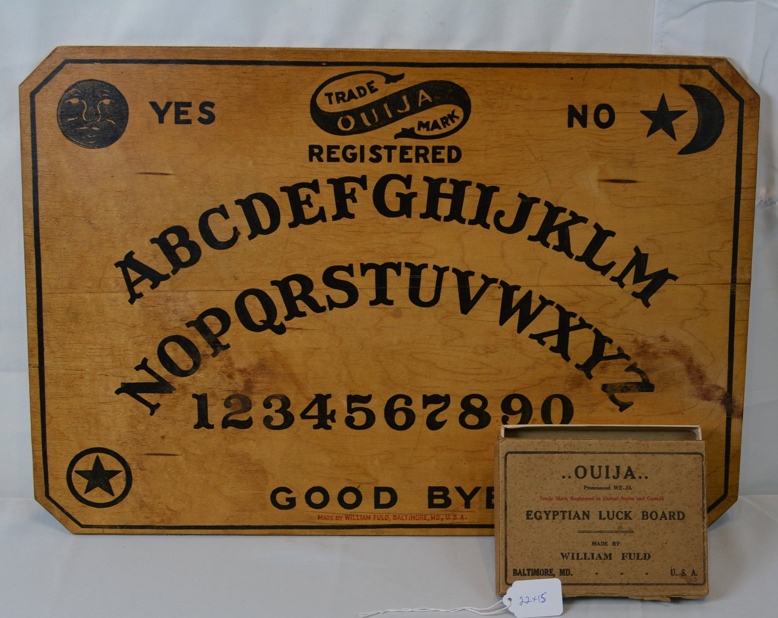 Early William Fuld Ouija Board with Original Box: Early 20th-century William Fuld Ouija Board, retaining its original cardboard box labeled “Ouija Egyptian Luck Board.” The board features the classic alphabet arc, numbers, celestial motifs,