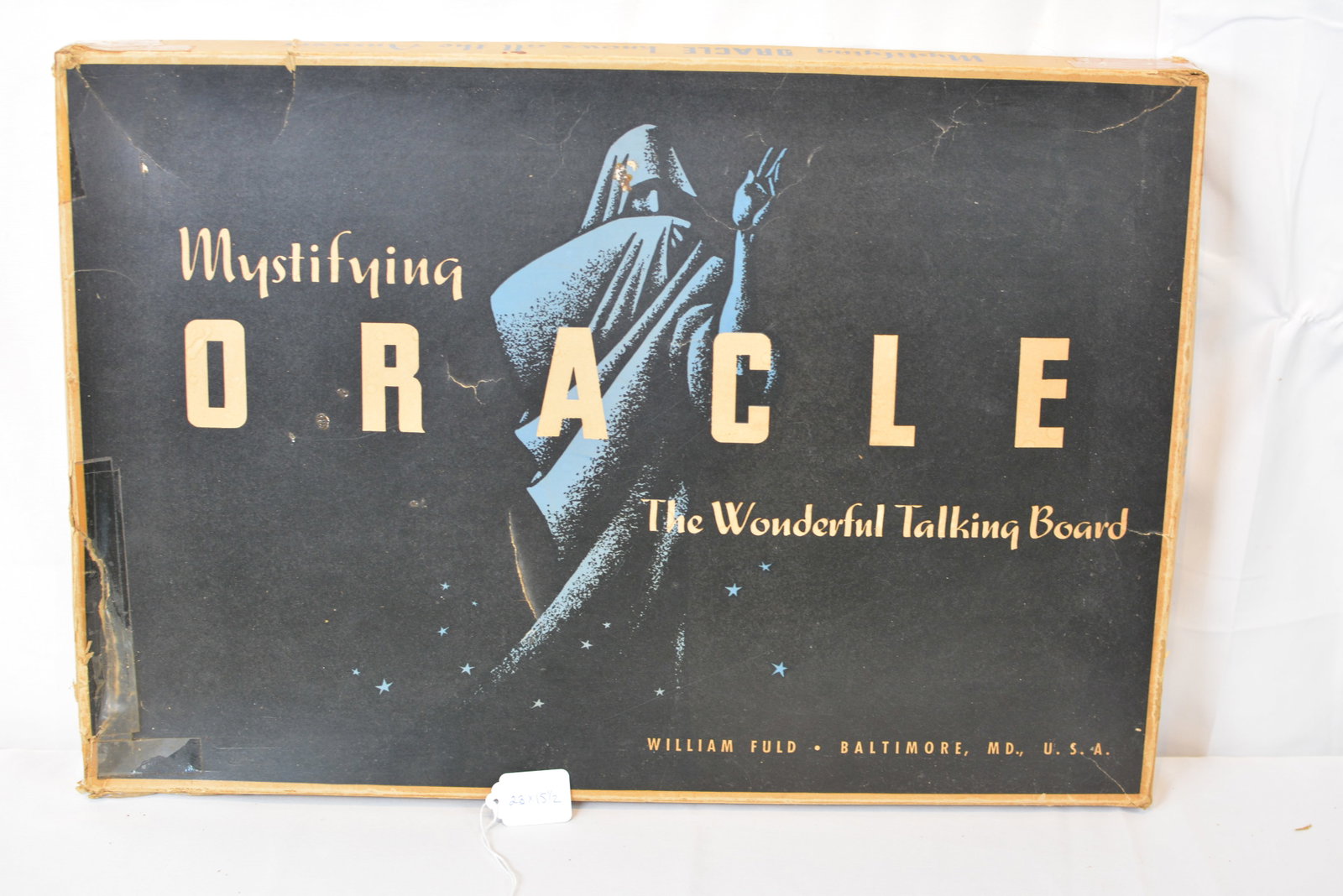 William Fuld "Mystifying Oracle" Talking Board with Original Box and Planchette: Scarce William Fuld "Mystifying Oracle" talking board complete with its original illustrated box and matching wooden planchette. The board features the classic alphabet and numeral layout with