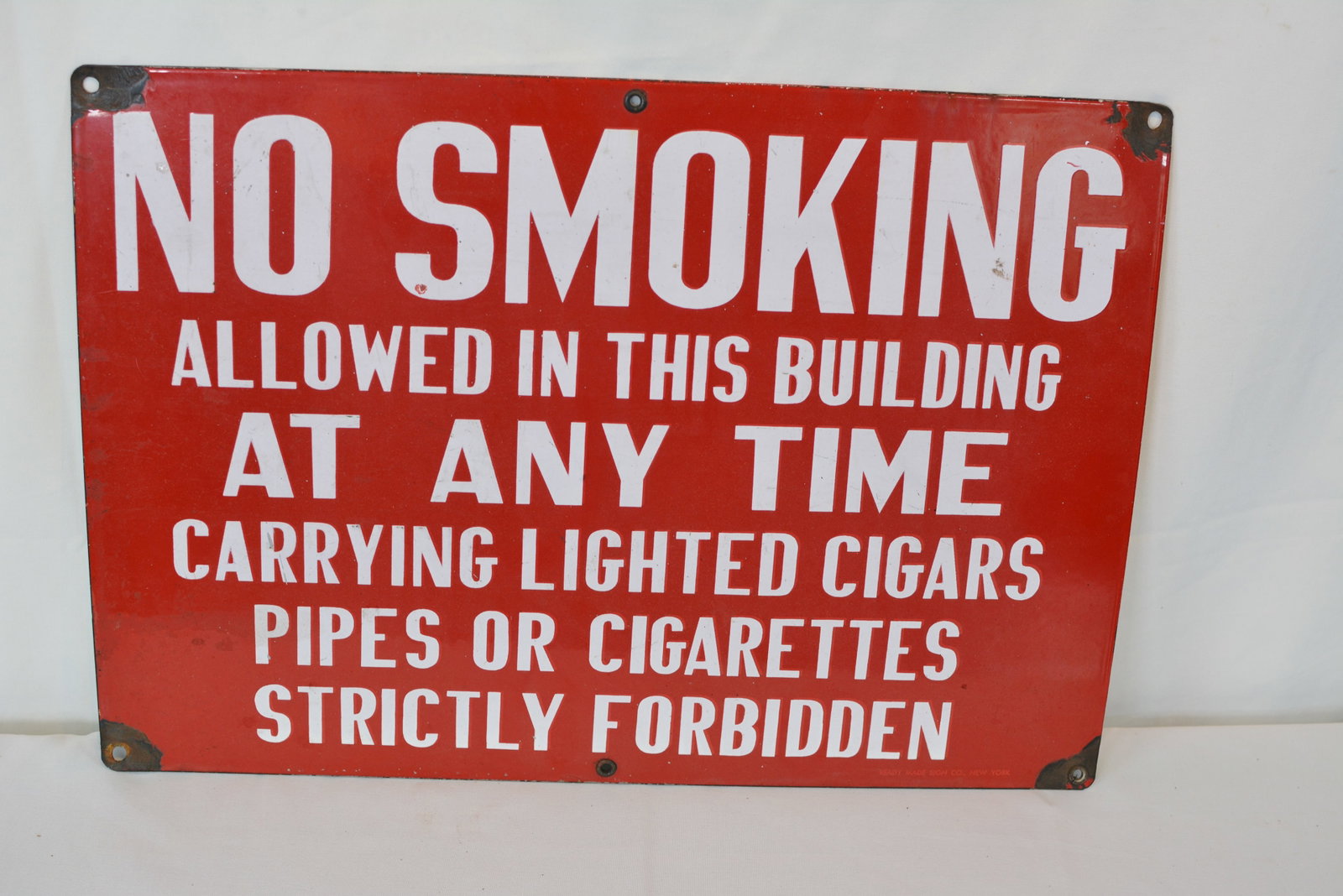 Vintage Porcelain “No Smoking Allowed in This Building?? Industrial Safety Sign: Original vintage porcelain-on-steel industrial safety sign featuring a bold red background with white block lettering reading:"NO SMOKING ALLOWED IN THIS BUILDING AT ANY TIME – CARRYING LIGHTED