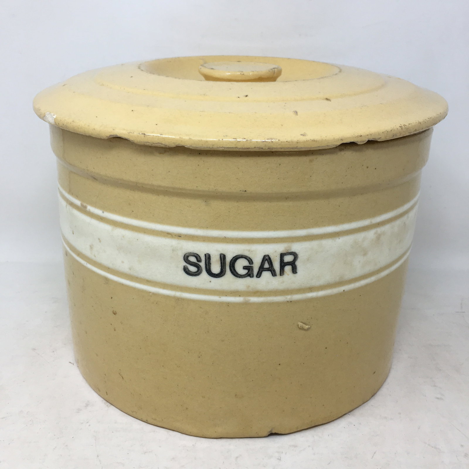 Banded Yellowware Sugar Crock With Lid: Banded Yellowware Sugar Crock With Lid. Chips to underside of lid. 9.5"D x 7.5"H.