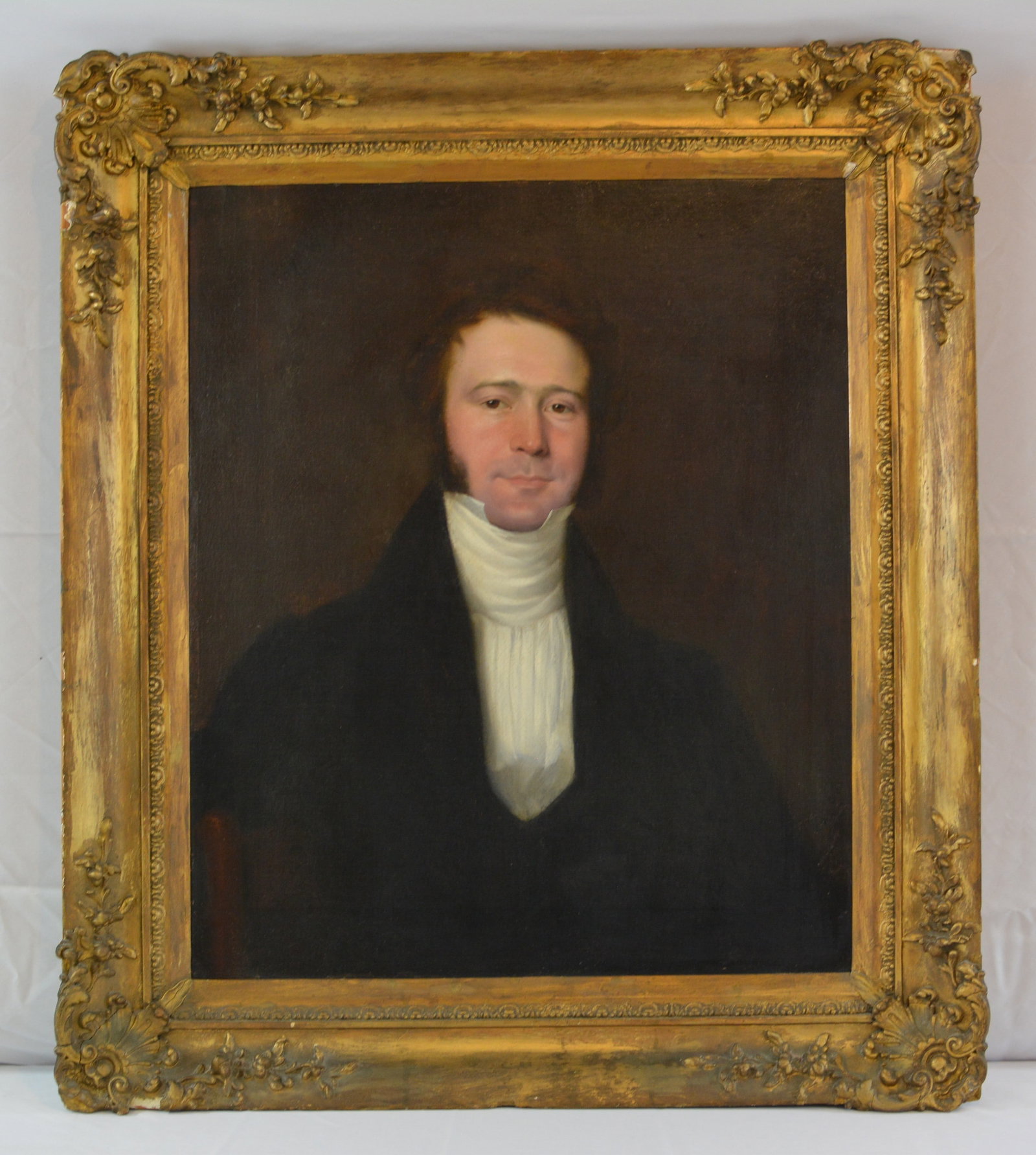 19th Century Portrait Painting of Gentleman: Early 19th century American oil on canvas portrait depicting a well-dressed gentleman wearing a dark coat with high white stock and pleated shirt front, dark background in the traditional formal
