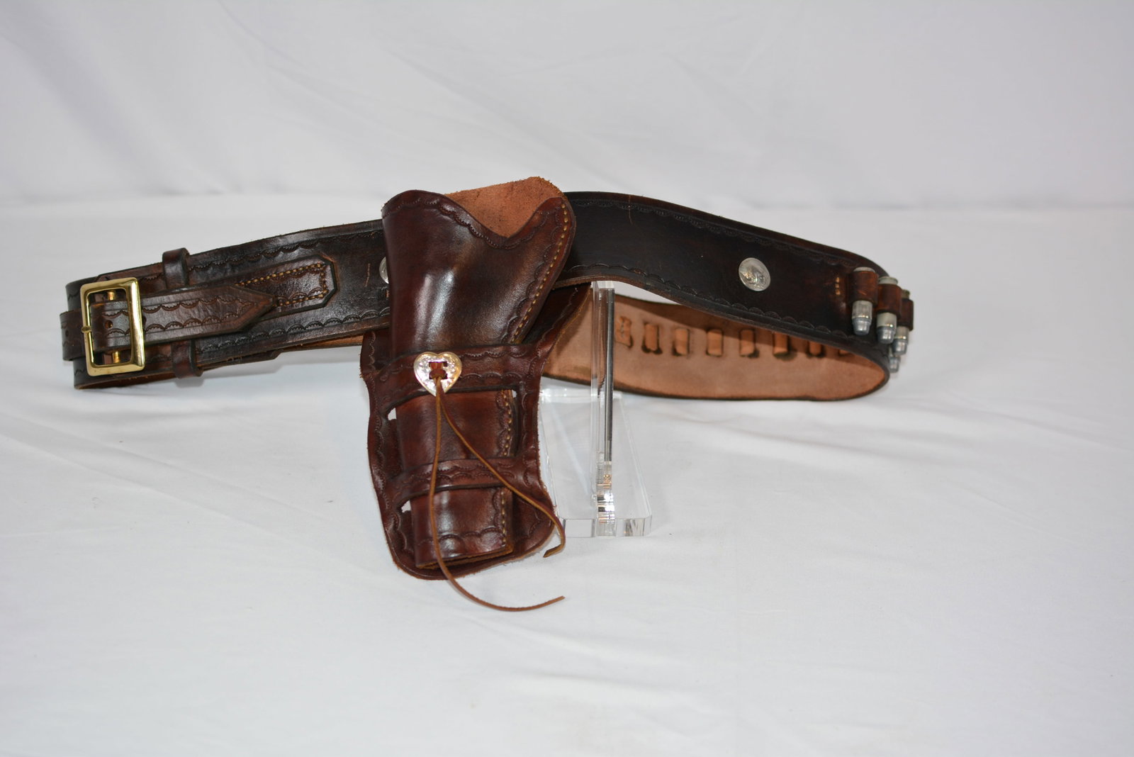 Vintage Western Tooled Leather Gun Belt & Holster: Vintage Western cowboy gun rig consisting of a heavy leather cartridge belt with fitted revolver holster. The dark brown leather features decorative tooling and stitching, brass-tone buckle, metal