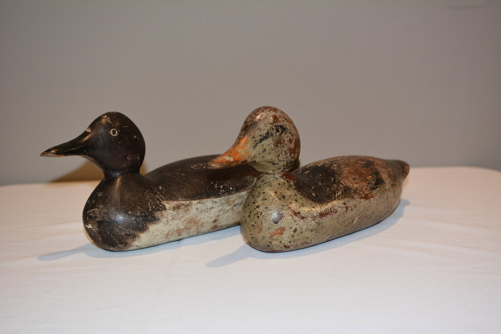 Pair of Early Hand-Carved Working Duck Decoys, Original Paint: Pair of early American hand-carved wooden working duck decoys, each exhibiting strong individual form with carved heads, tack or glass eyes, and substantial remnants of old painted surface. One retain