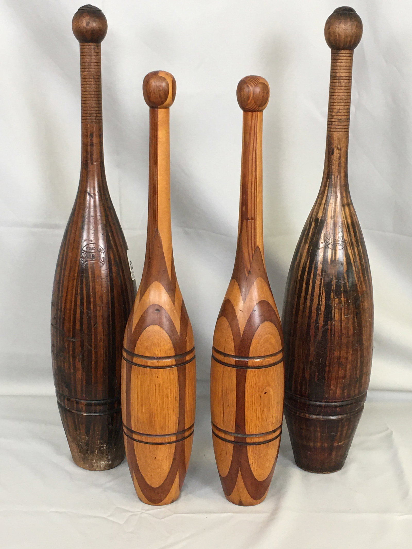 Wooden Indian Clubs: Turned Wood Indian Clubs or Juggling Pins. Tiger striped pair by Spalding; other pair mixed wood. Tallest 23.25"H