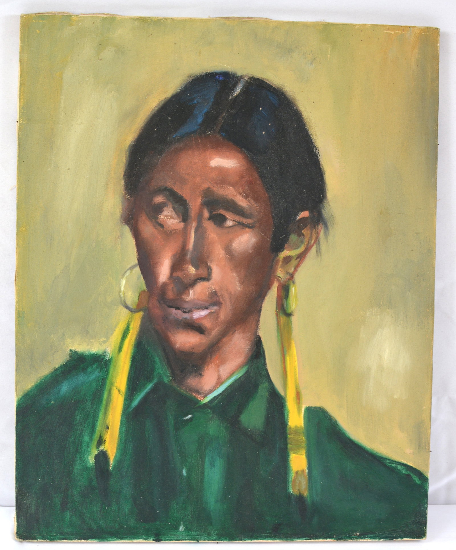 Vintage Oil on Canvas Portrait of Native American Woman: Oil on canvas portrait depicting a Native American woman wearing large hoop earrings with long yellow adornments and a deep green garment. Painted in a modernist style with strong facial modeling, ric