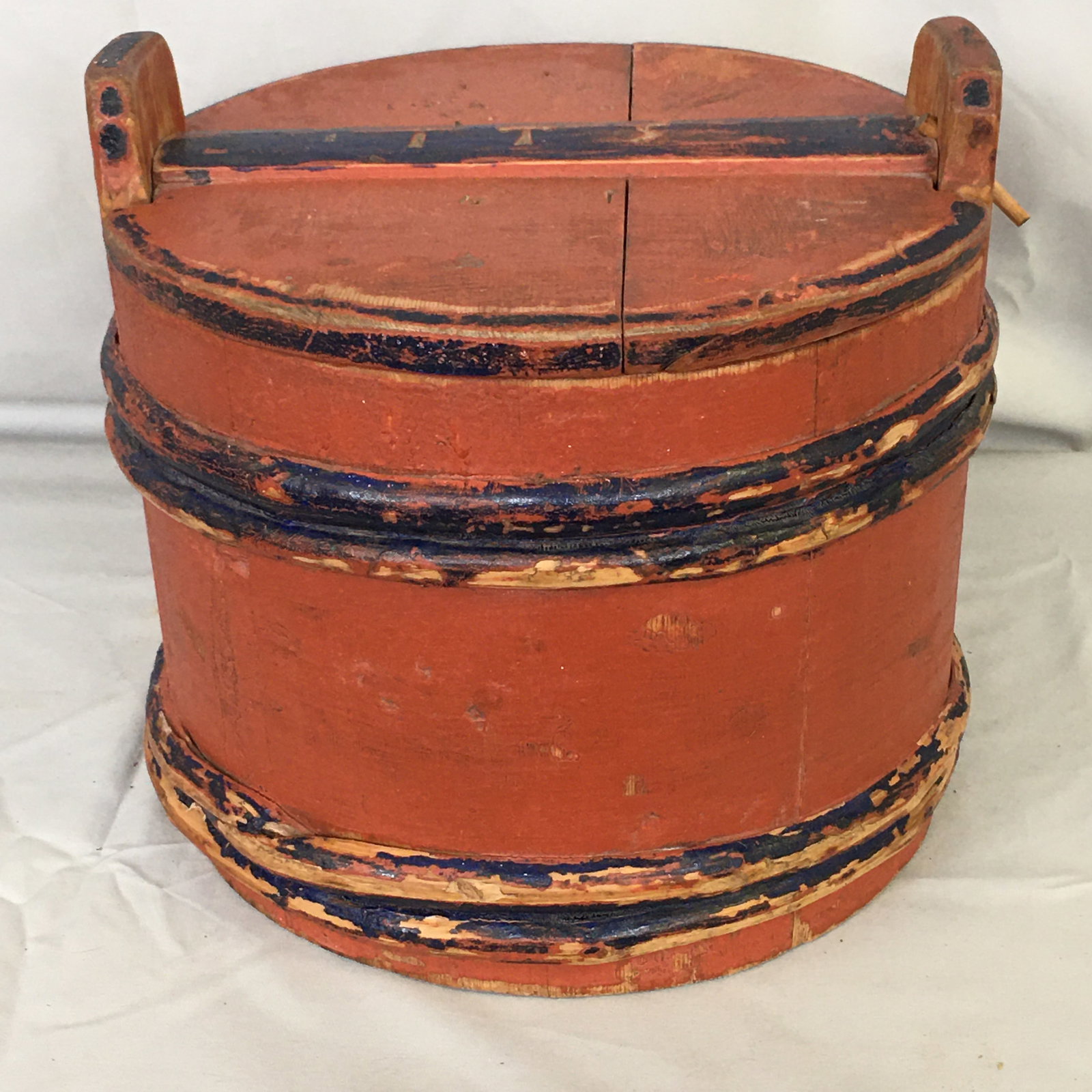 Painted Piggin With Lid: Painted Piggin With Lid. In salmon paint with blue accents. Lid pinned in place with wood peg. Initial "I T S" carved on top, and on bottom along with "1909". Solid construction. 10.25"D x 10"H.