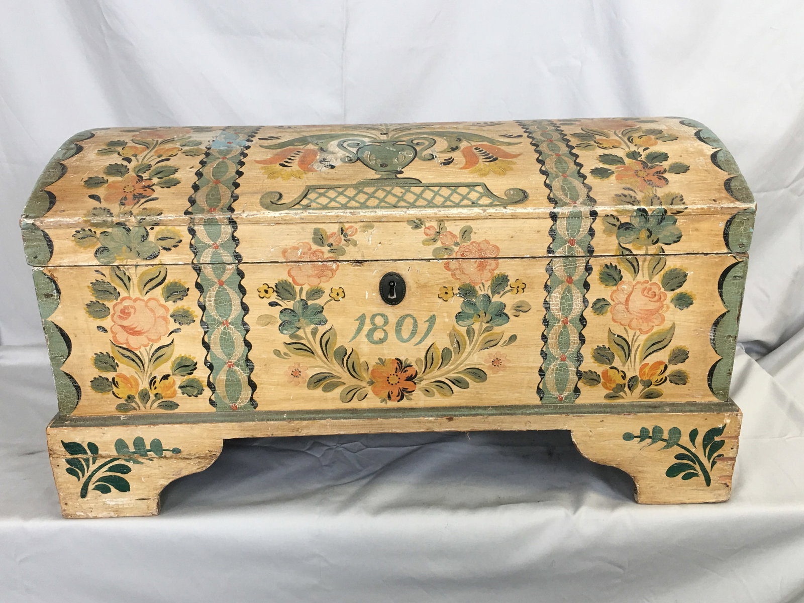Scandinavian Immigrant's Trunk, 1801: Scandinavian Immigrant's Trunk. Paint decorated dome top trunk, with a floral motif on a cream background and green interior, marked 1801. Repair to left front foot and loose piece at right side.