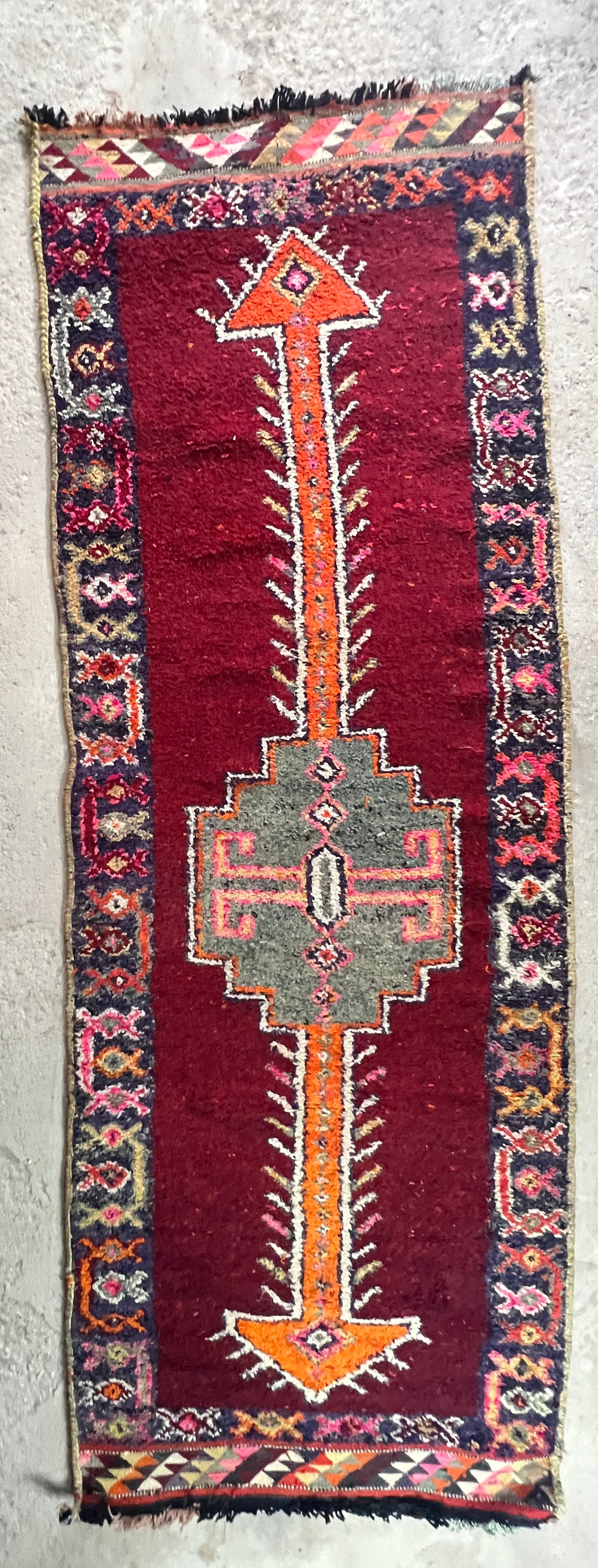 Vintage Tribal Hand-Knotted Wool Runner Rug with Kilim Ends: Distinctive vintage Anatolian Tribal wool runner featuring a deep burgundy field centered by a large stepped geometric medallion joined to elongated orange arrow-form devices. The rug has a dark