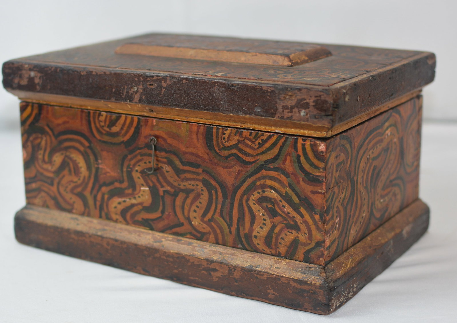19th Century Folk Art Paint-Decorated Box with Mirror: Unusual 19th-century American folk art wooden box extensively decorated with freehand, swirling painted designs in red, ochre, green and black. The hinged lid opens to reveal an inset mirror, with a