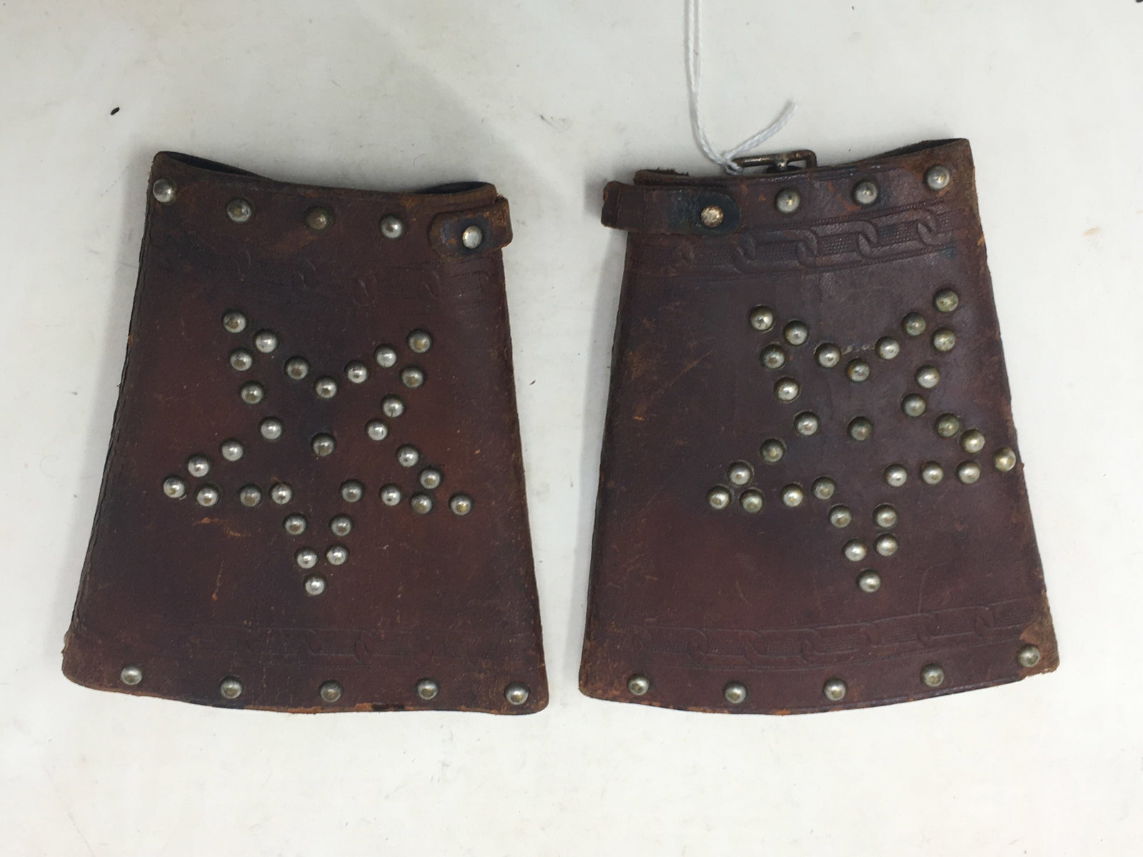 Antique Tooled Leather Studded Cowboy Cuffs: Antique Tooled Leather Cowboy Cuffs with studded star design. Missing straps and one buckle. 5.75"