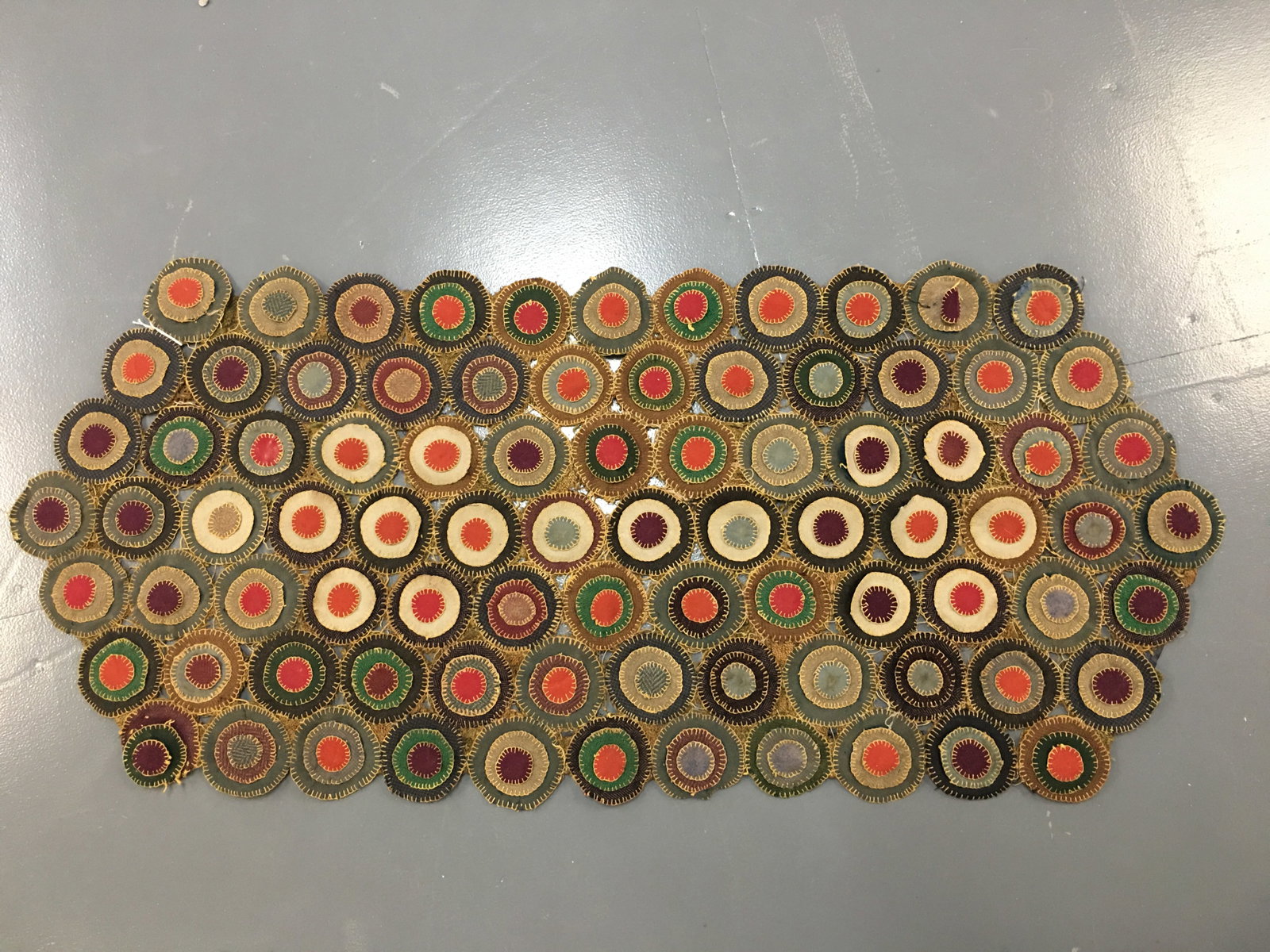 Antique Handstitched Penny Table Runner: Antique Handstitched Penny Table Runner. Concentric circles of assorted colors & fabrics, with burlap backing. Some loose stitching and spotting. 47.25"x 21"