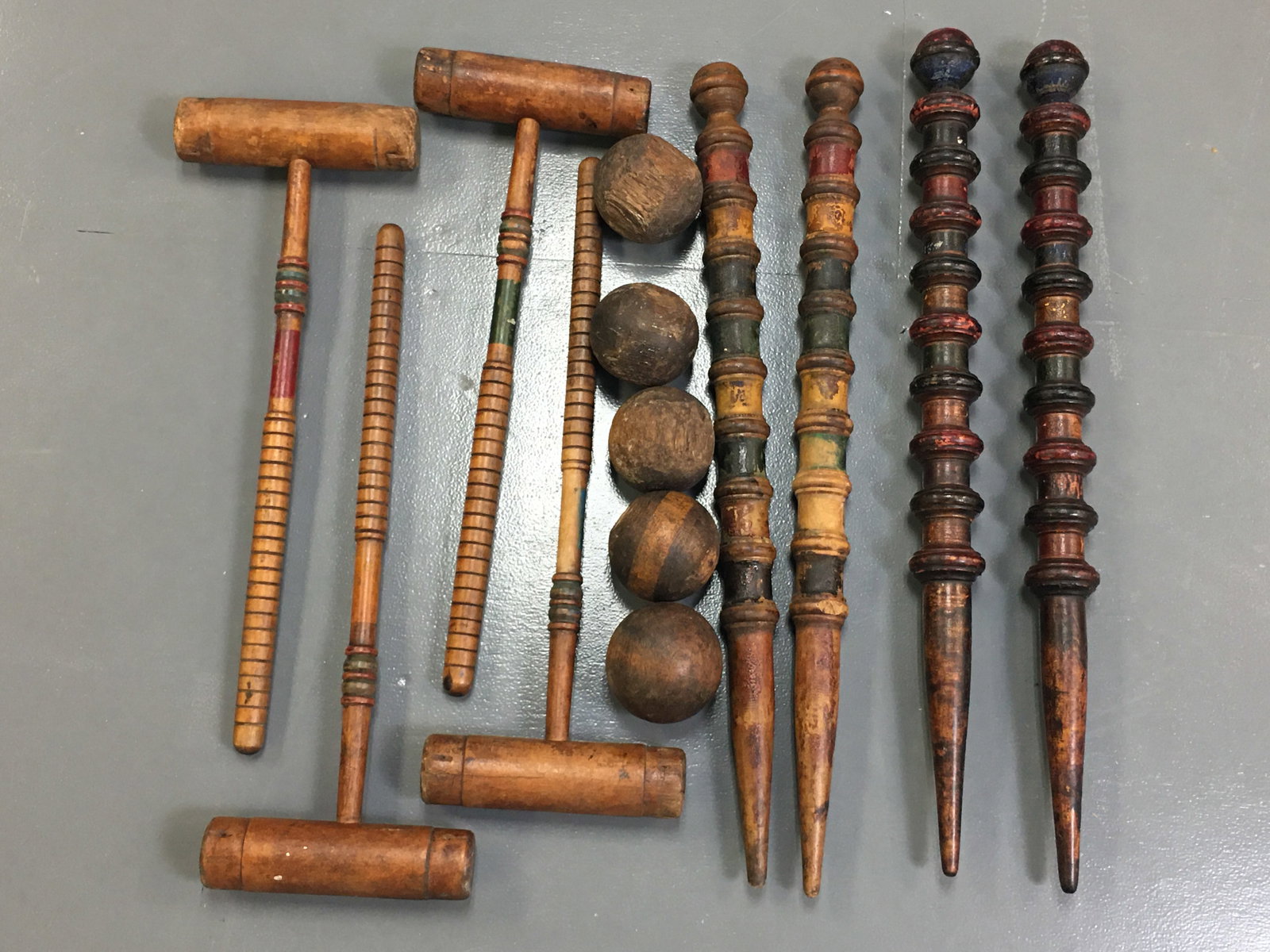 Old Wooden Lawn Croquet Set: Old Wooden Lawn Croquet Set. Four mallets, five balls, and four elaborate turned end-of-course marker stakes. All with vintage paint and age/use related wear. Longest piece 27"
