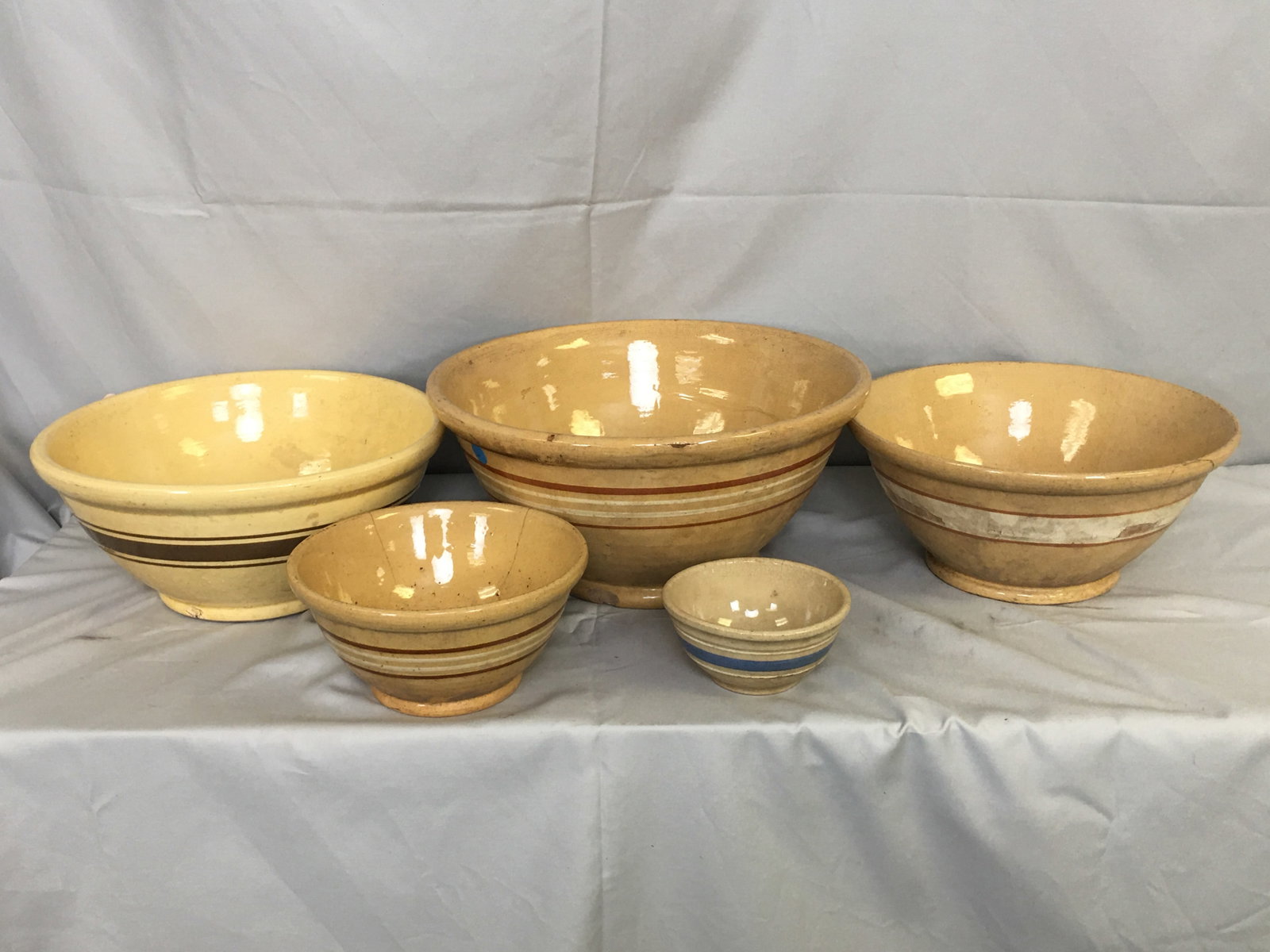Group of Banded Stoneware Bowls: Group of Banded Stoneware Bowls. 5 bowls of assorted sizes with white, brown & blue bands. Largest 14"D.