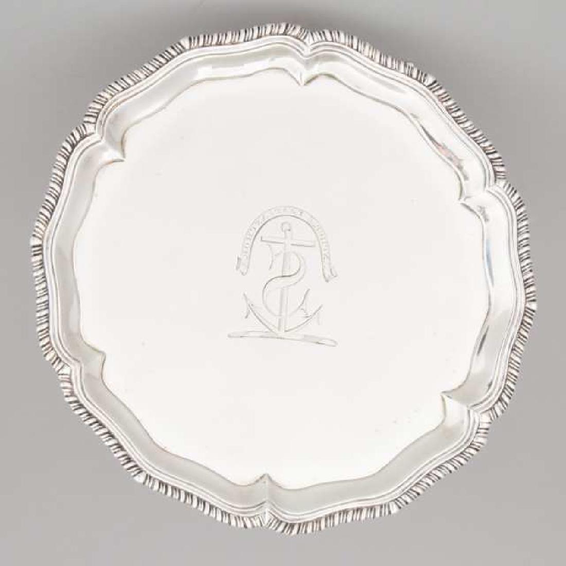 George III Silver Shaped Circular Salver, John Carter: Lot 48 George III Silver Shaped Circular Salver, John Carter II, London, 1769 with moulded gadroon rim on three hoof feet, engraved on the centre with a crest and motto 'ANCHOR FAST ANCHOR' diameter 8