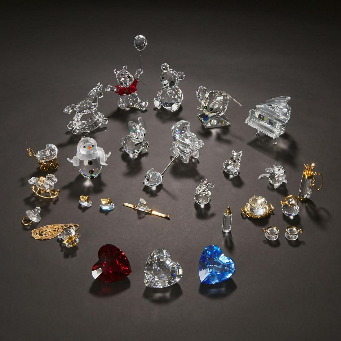 Group of Swarovski Crystal Decorative Objects, late: Group of Swarovski Crystal Decorative Objects, late 20th/early 21st centurycomprising: 11 figures, 3 hearts, 13 dollhouse items, and a bear necklace, largest height 4.3 in — 11 cm, Swarovski sta