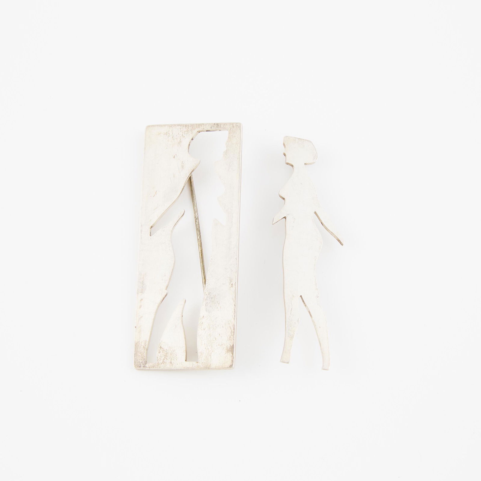 Pair Of Michael Snow Canadian Sterling Silver Brooches, wit: PAIR OF MICHAEL SNOW CANADIAN STERLING SILVER BROOCHESwith a cutout designlength 2.5 in — 6.4 cm, 25.9 grams, marked AGO 1994; numbered #71 & #73 of 800Estimate: $80—120