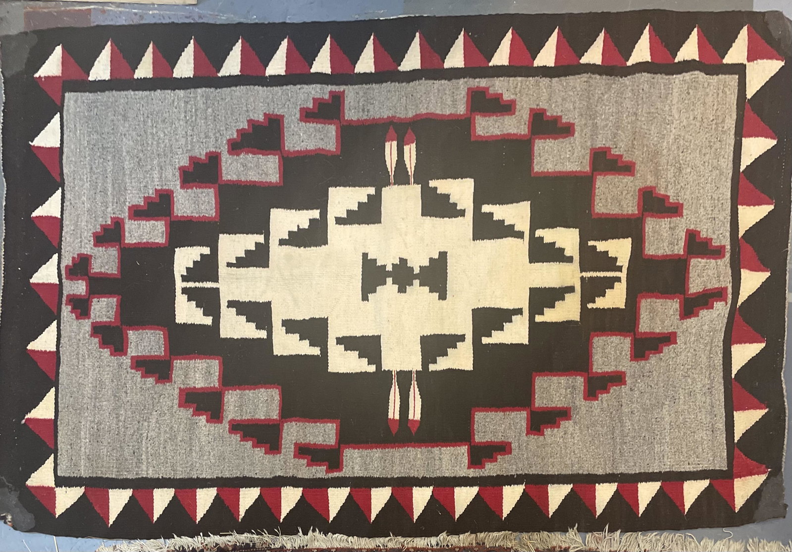 Two grey hills Navajo rug: Beautiful red, white, grey and black pattern. Excellent condition except for minor losses in one corner. Dimensions: 55” x 34”